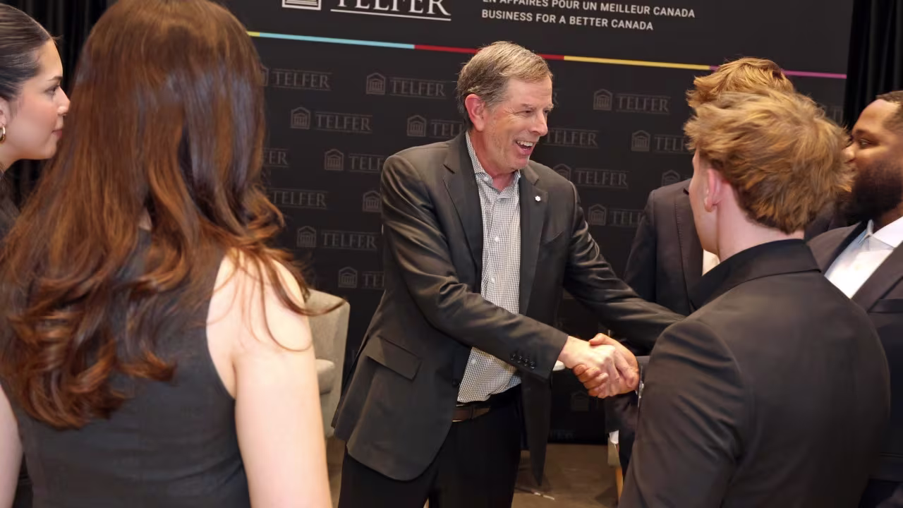 Roger Greenberg shaking hands with Telfer students.