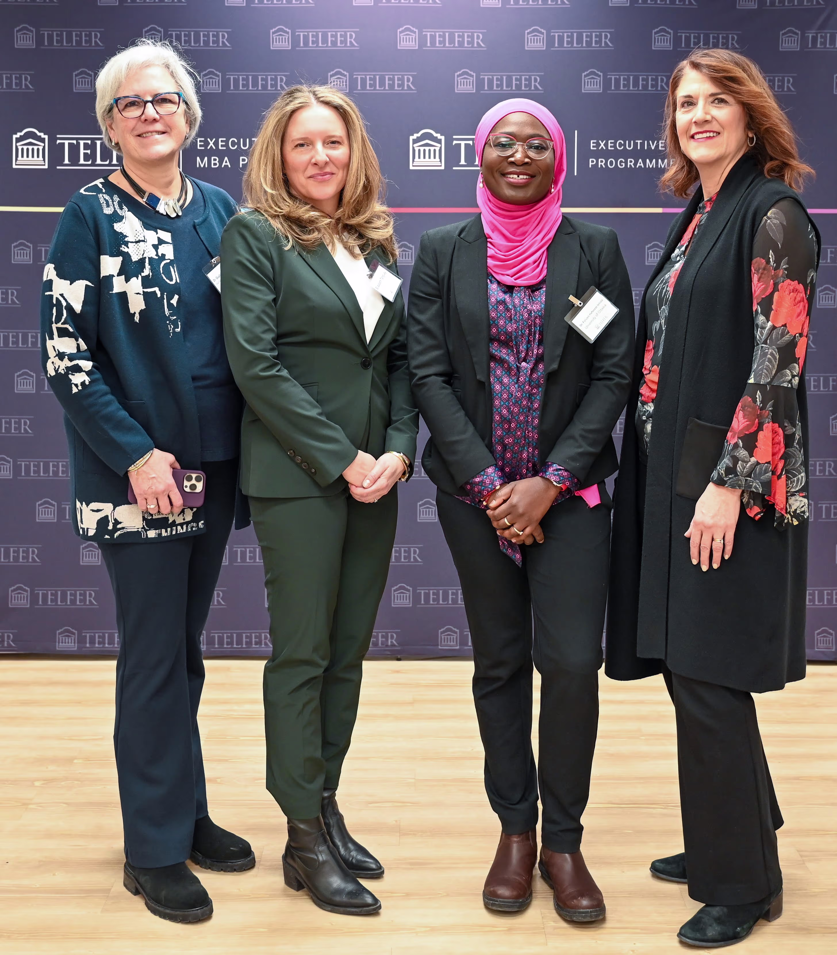 Panelists Dr. Chantal D'Aoust-Bernard, Dr. Guylaine Lefebvre, Dr. Foluso Hafeezat Ishola, and moderator Elizabeth Tanguay stand in front of the Telfer banner at Telfer’s Executive Campus on March 5, 2025.
