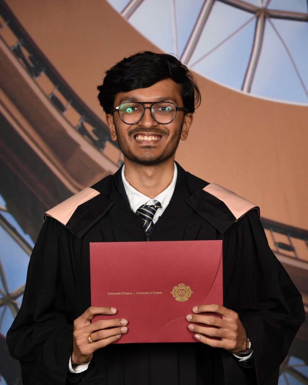 Dipen holding his diploma