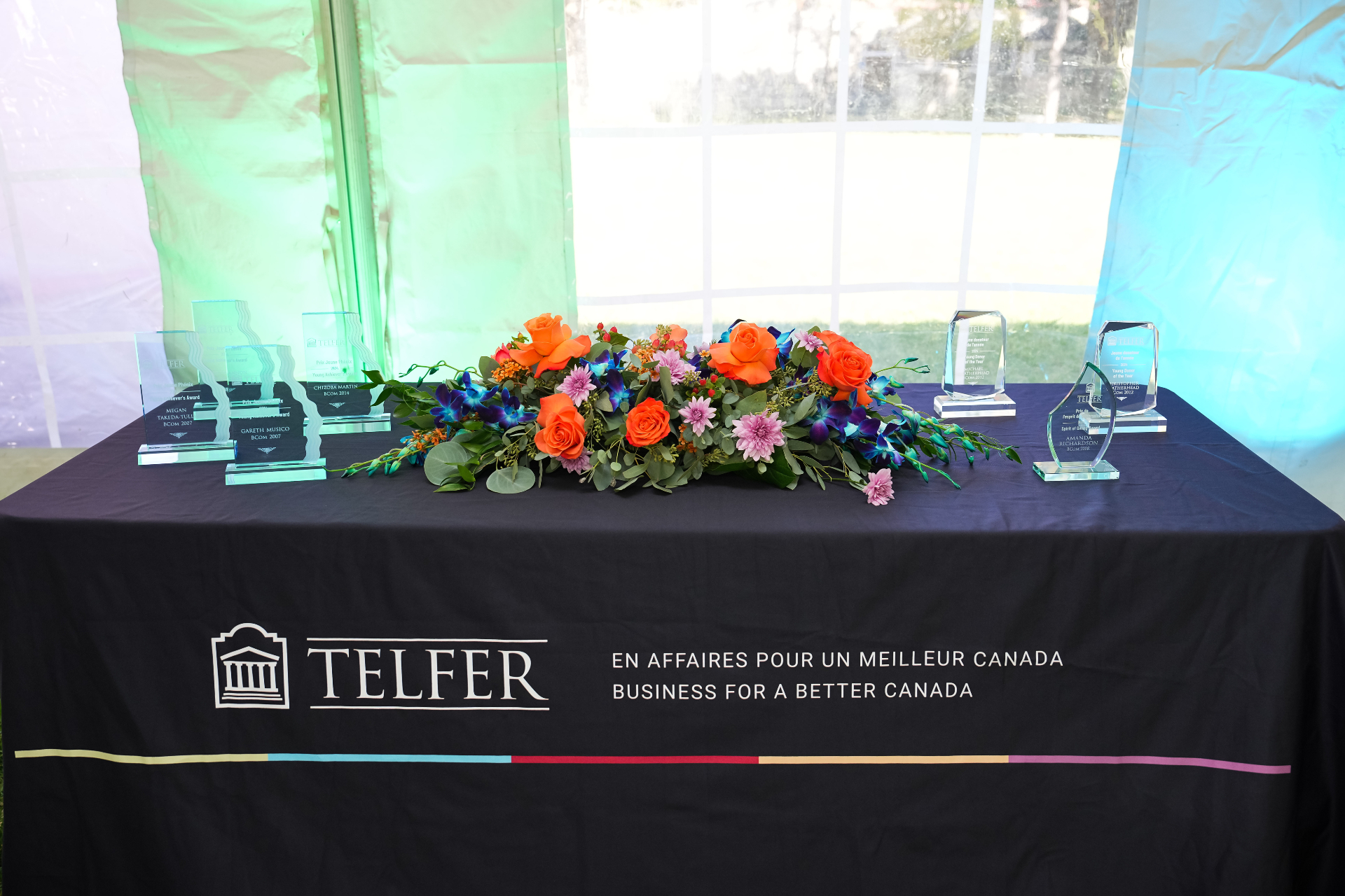 Awards are arranged next to flowers on a table