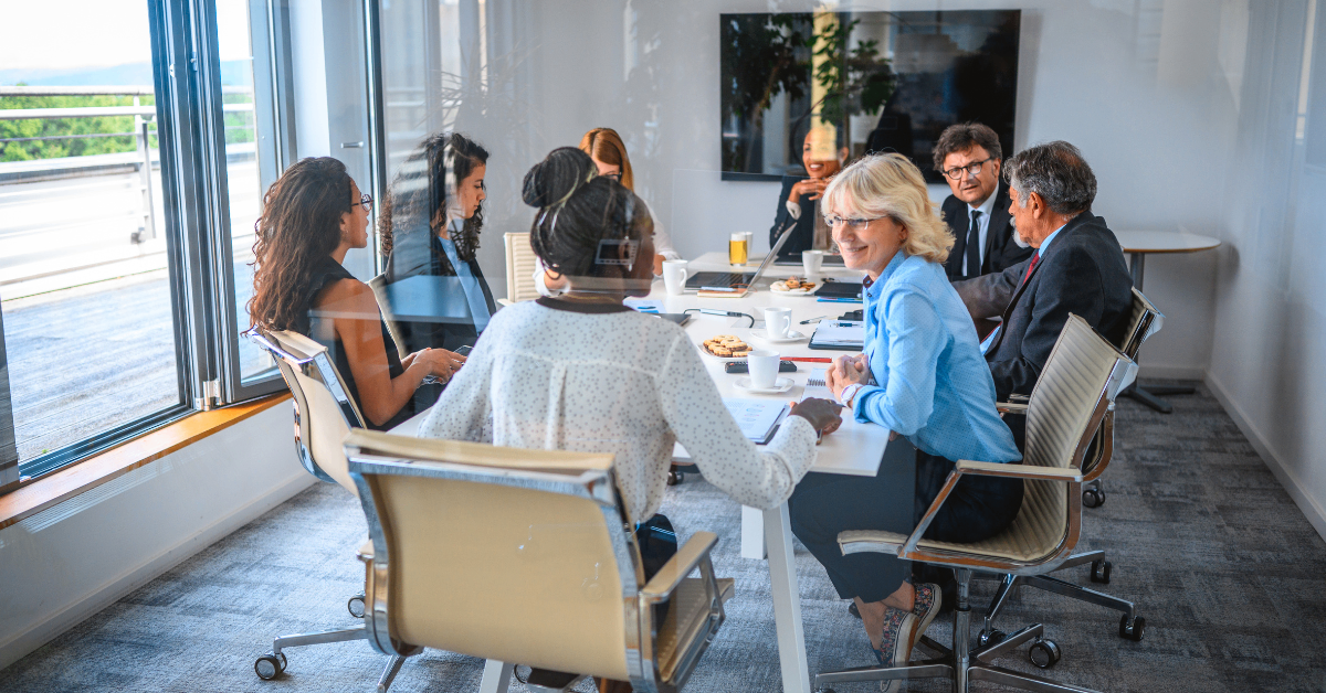 group of people around a boardroom table having discussions