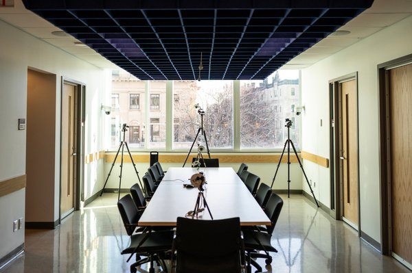 Une salle de conseil avec une table et douze chaises.
