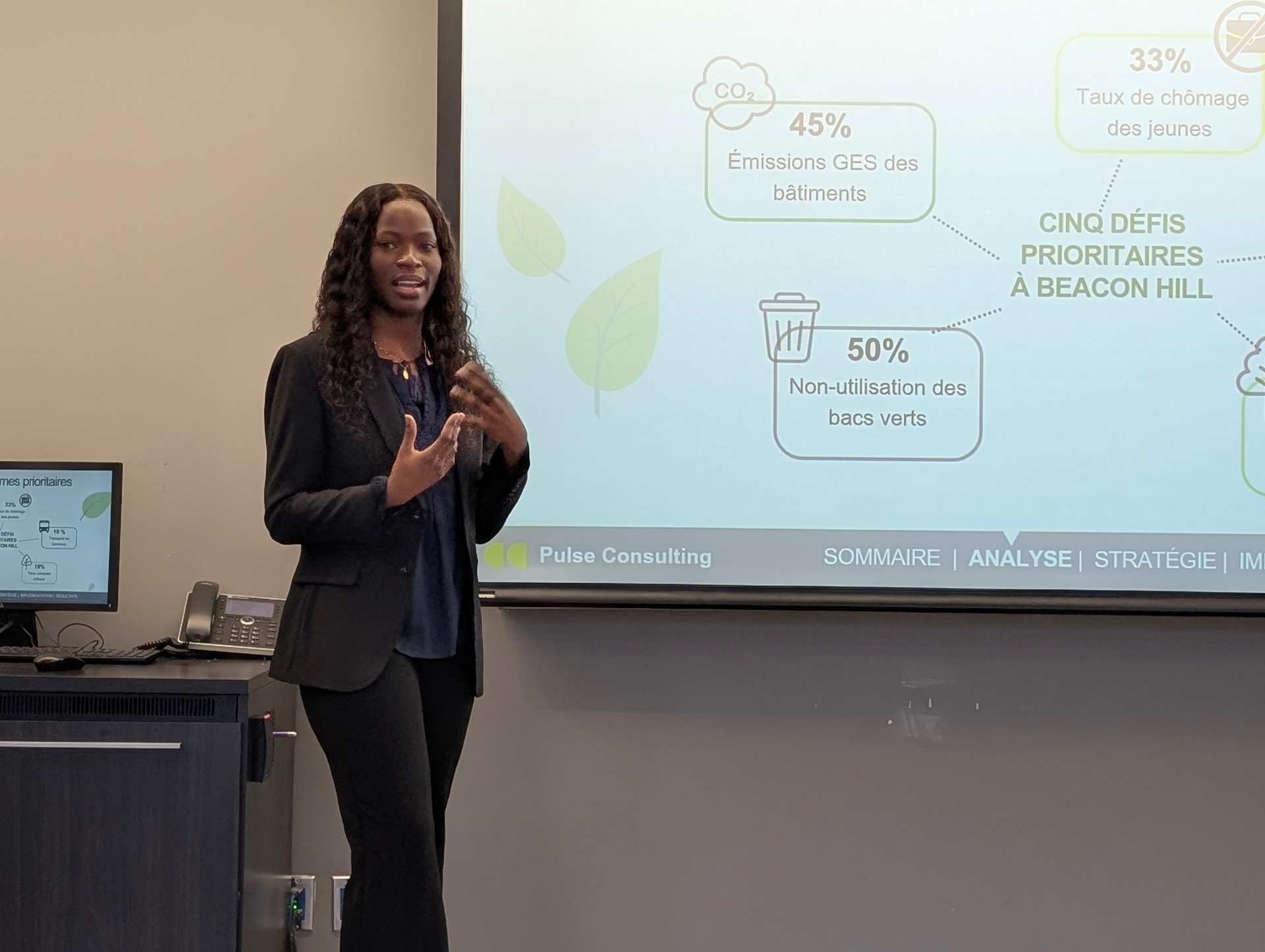A student presents key sustainability challenges using a visual diagram on a projected slide, speaking to the audience during a final course presentation.