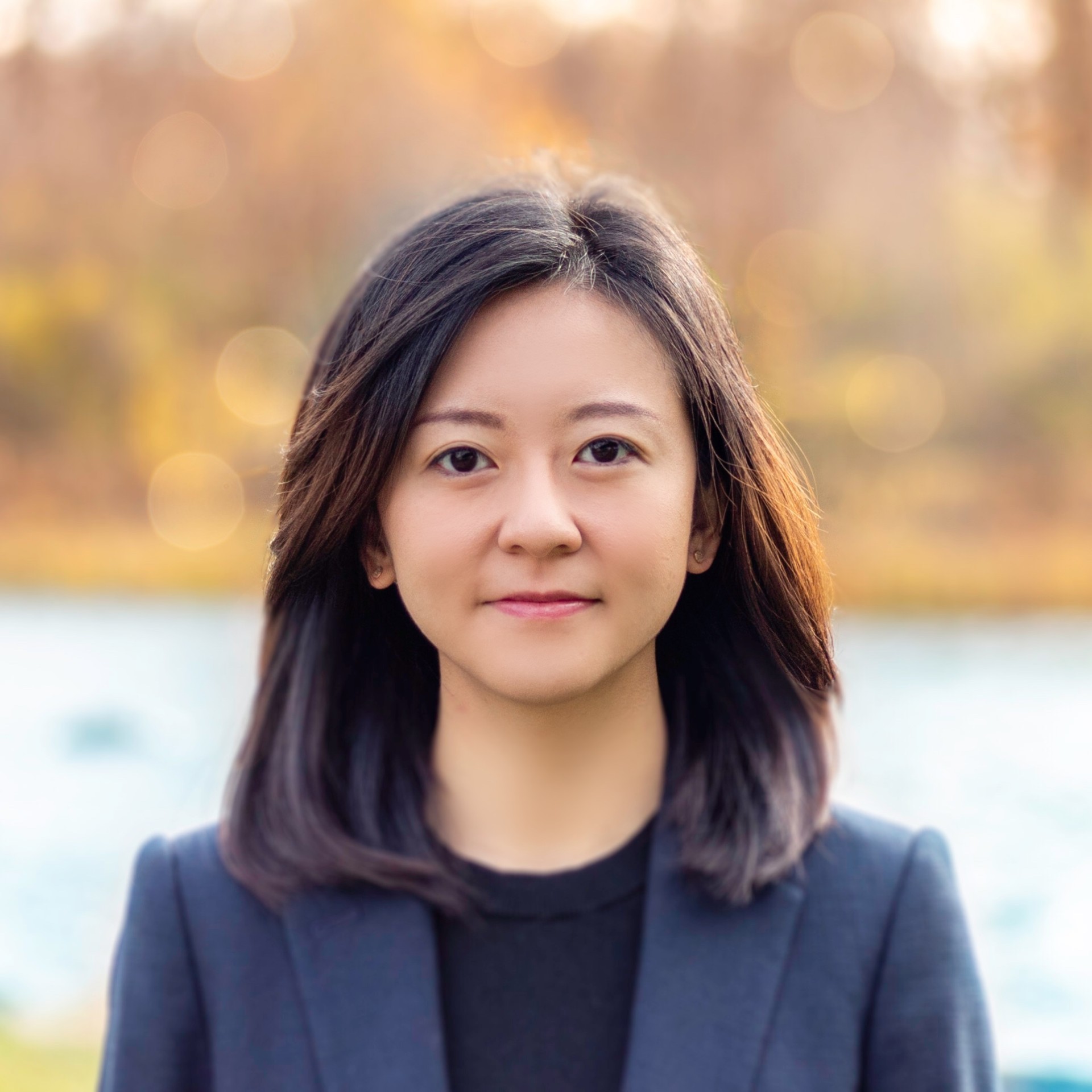 A profile picture of Nina Sun, shown from the shoulders up in a dark blazer against a softly blurred background.