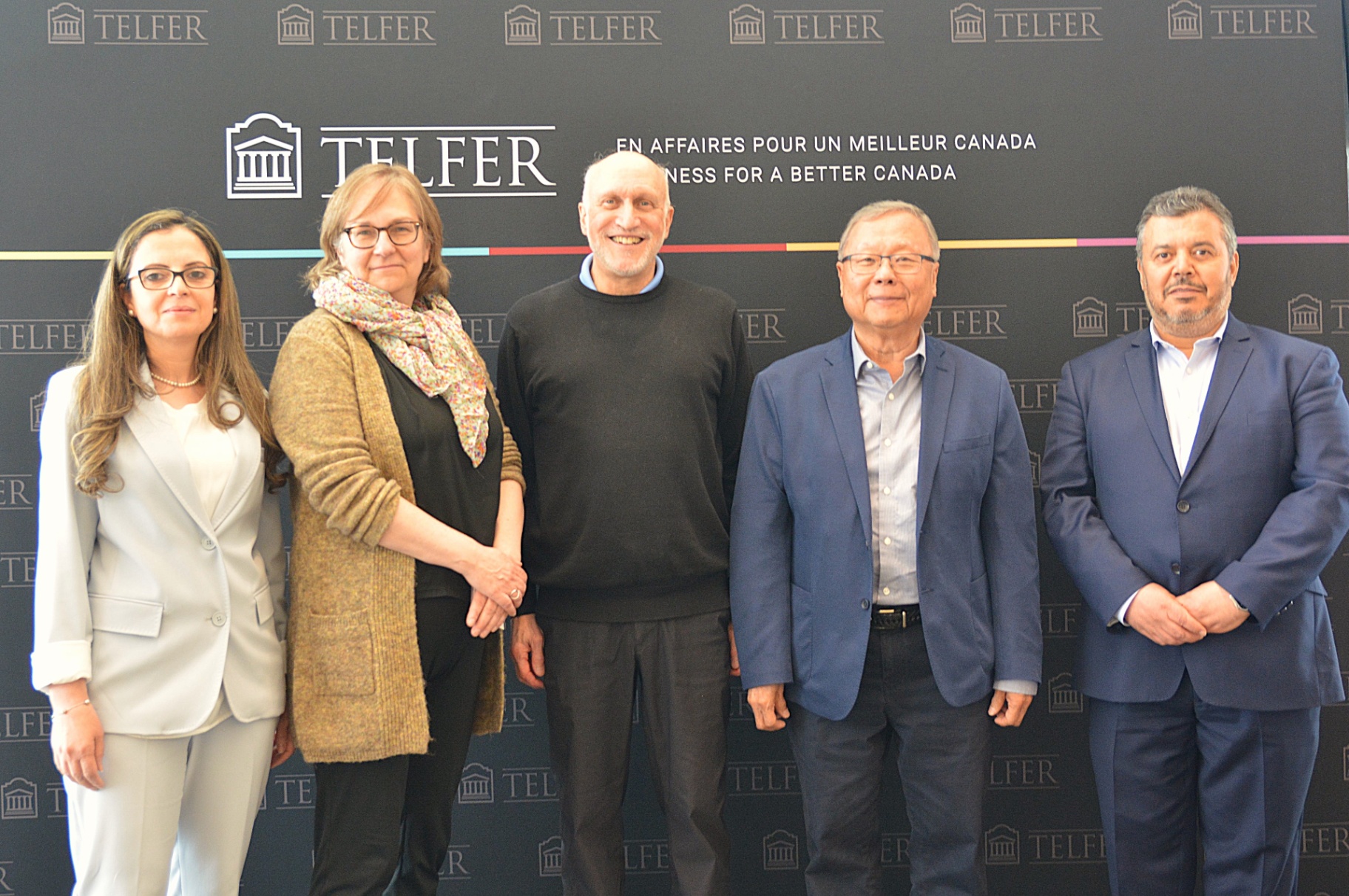 Quatre membres du corps professoral de l’École de gestion Telfer se font photographier devant un fond noir en compagnie de Swee Goh (le deuxième à partir de la droite).