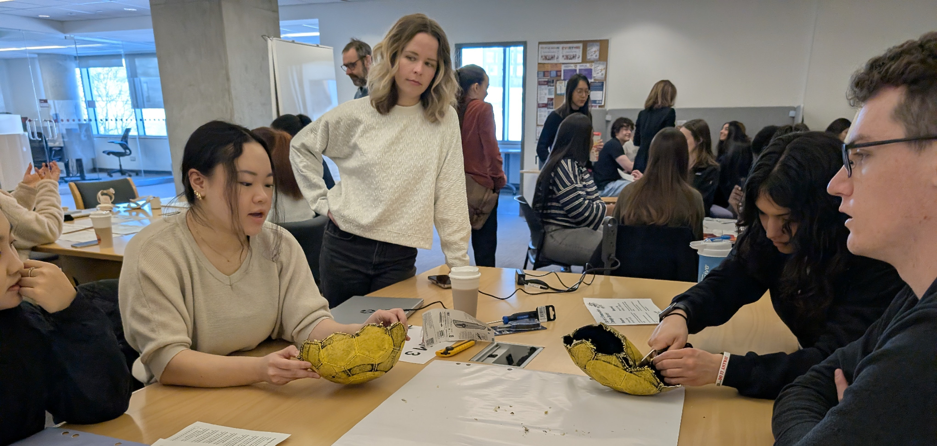 Group of students cutting open a soccer ball to explore its materials and structure.
