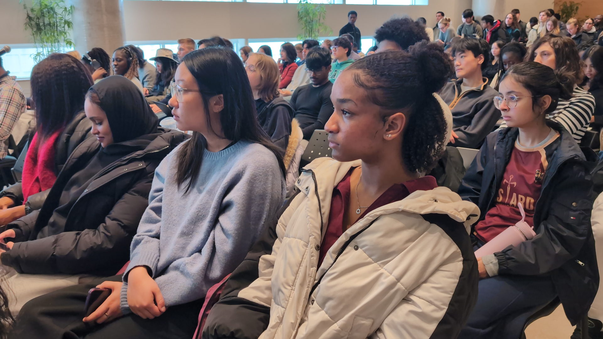 Audience of students attending and listening during a sustainability event.