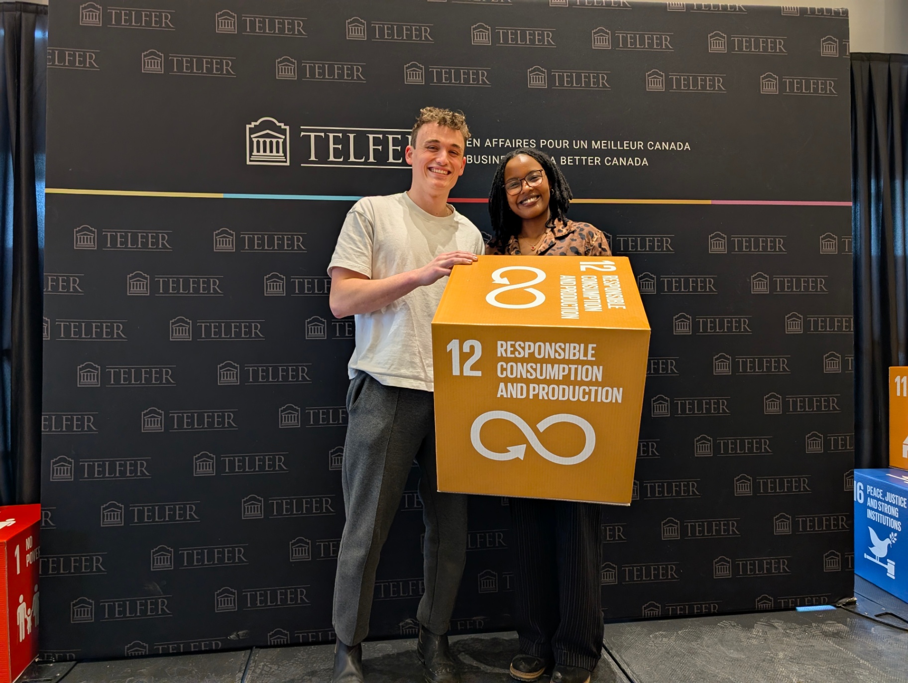 Two students holding an SDG 12 cube during the Innovation Sprint.
