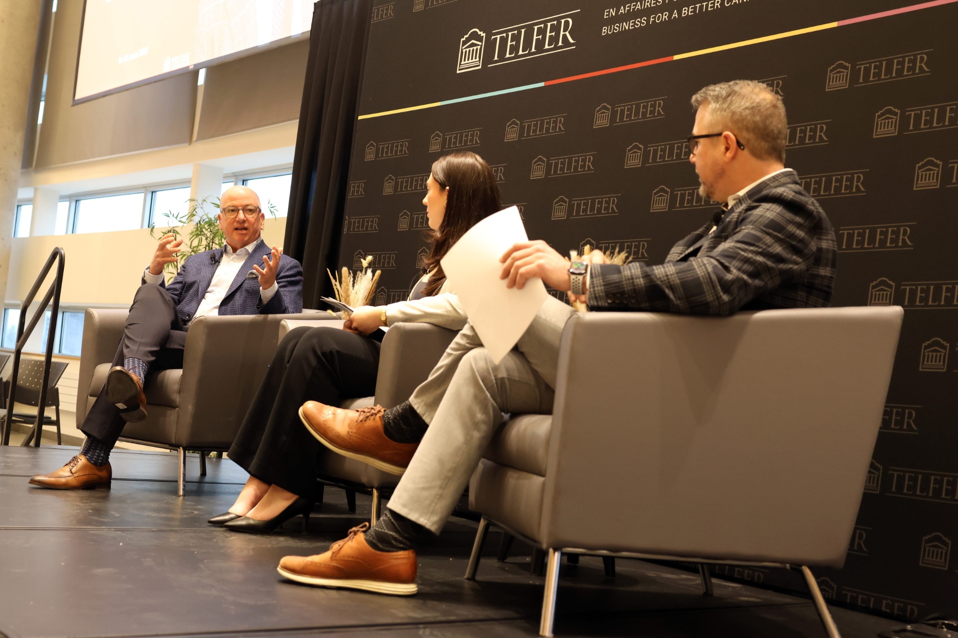 Hugh Gorman seated on stage with two moderators