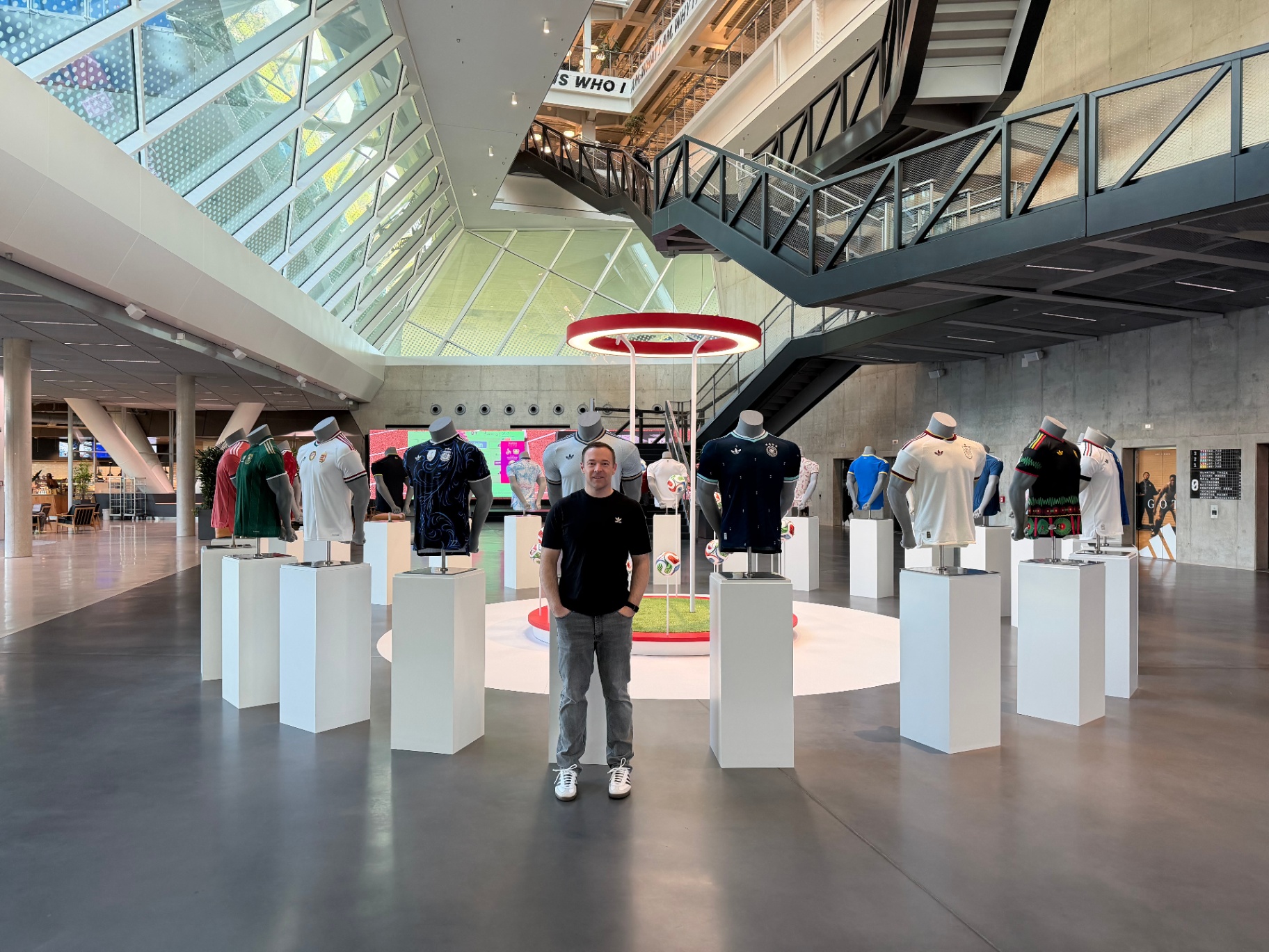 Jonathan Cavalier stands next to a display of international soccer jerseys on mannequins at the adidas headquarters in Germany.