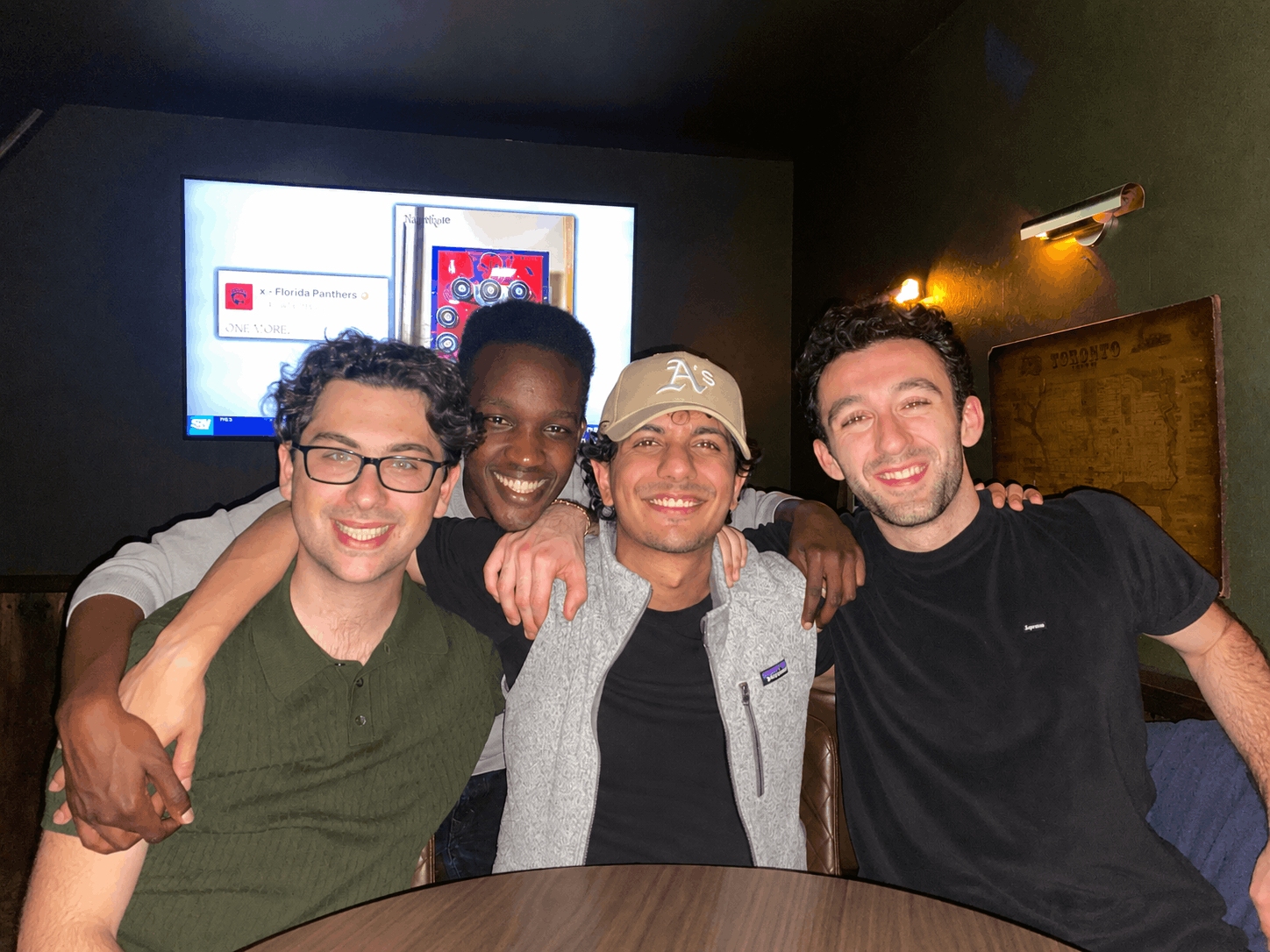 Zain Ahmed, valedictorian and Bachelor of Commerce graduate in Finance, seated with three fellow students during his time at Telfer School of Management.