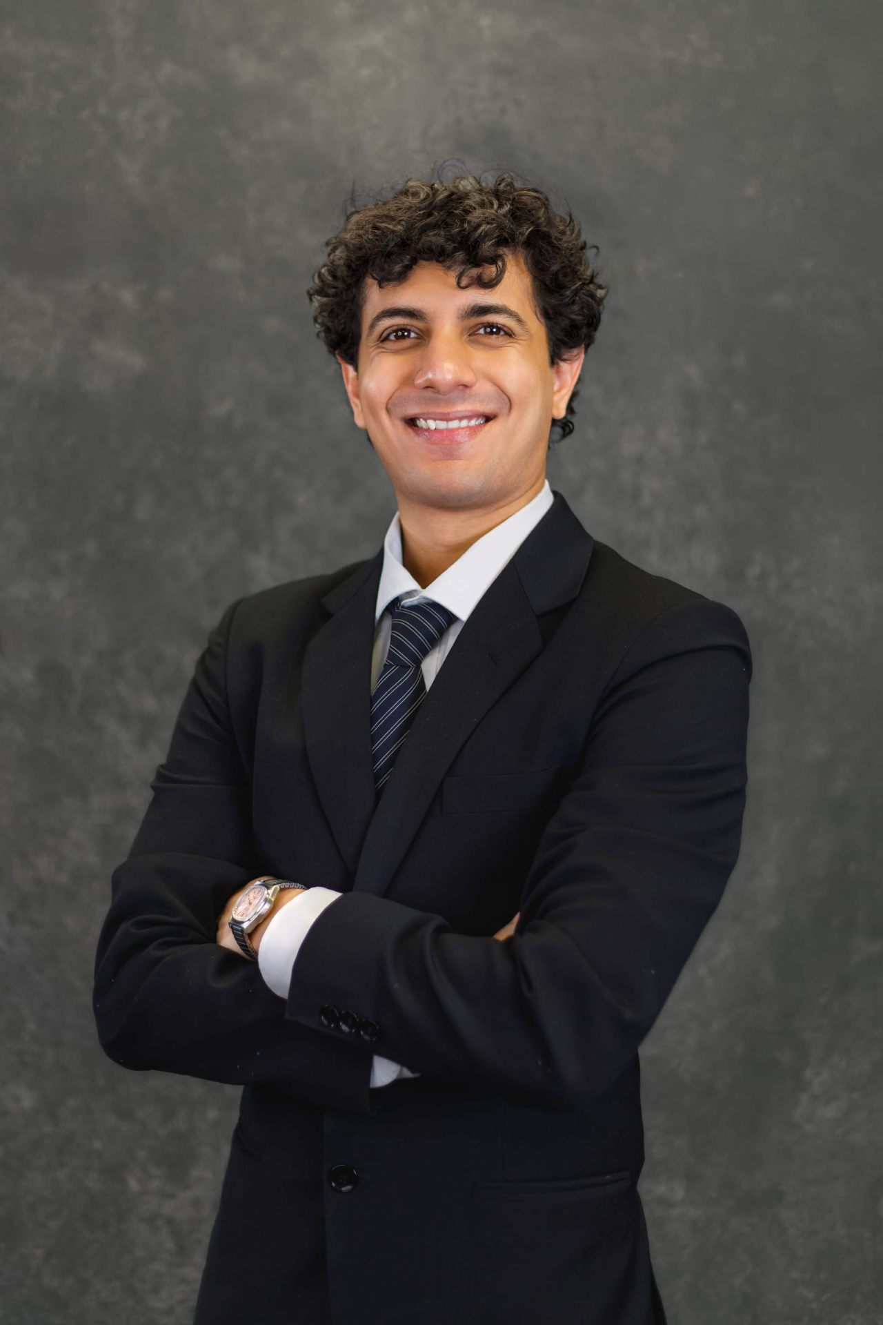 Zain Ahmed, valedictorian and Bachelor of Commerce graduate in Finance, posing in a professional portrait wearing a dark suit and tie.