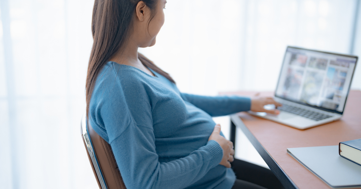 pregnant woman sitting at a computer desk