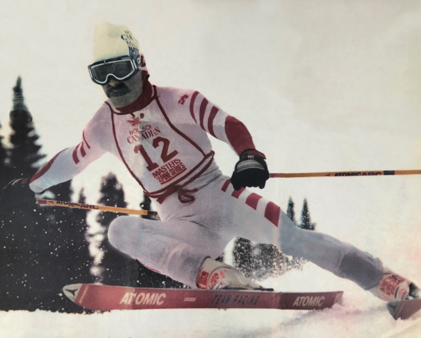 Richard Hunter descend une piste de ski, prot&eacute;g&eacute; par des lunettes de ski et une combinaison de ski blanche et rouge aux couleurs de Molson Canadian.