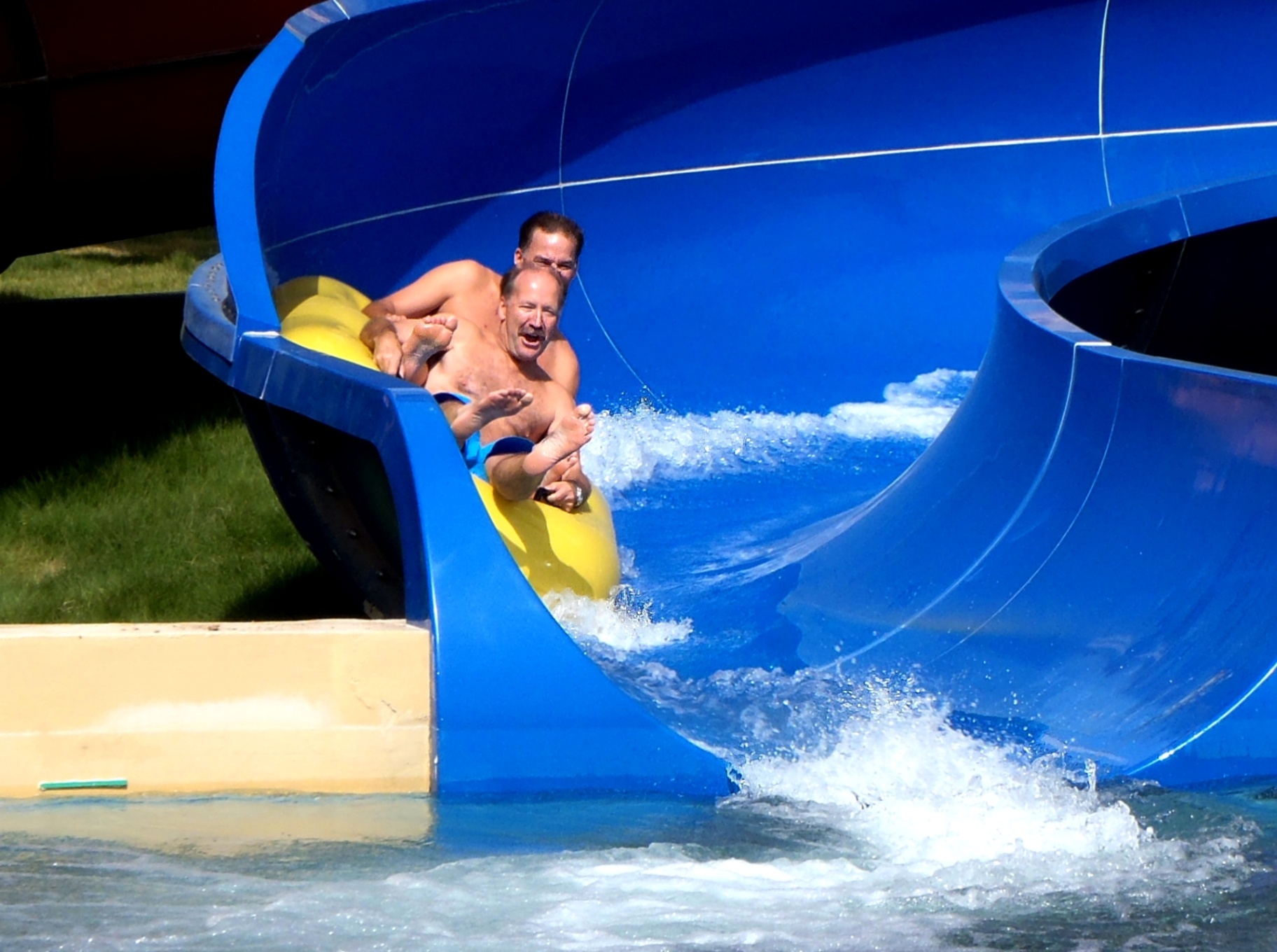 Richard Hunter d&eacute;vale une glissade d&rsquo;eau bleue en arborant un large sourire.