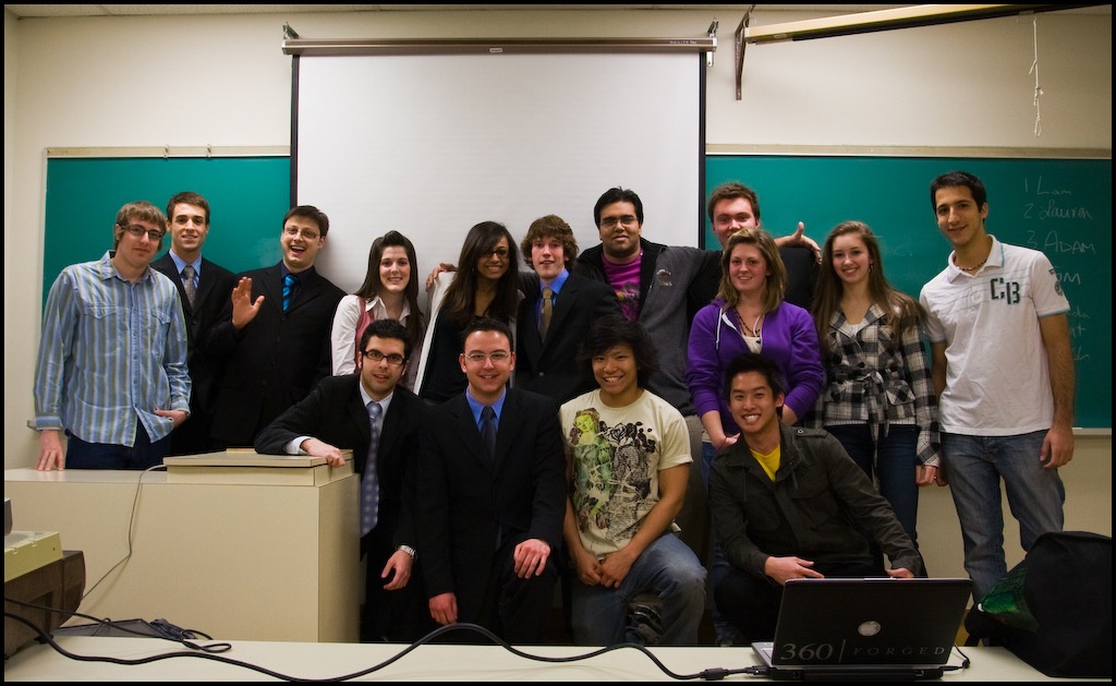 Un groupe d'&eacute;tudiant pose devant un tableau vert de classe