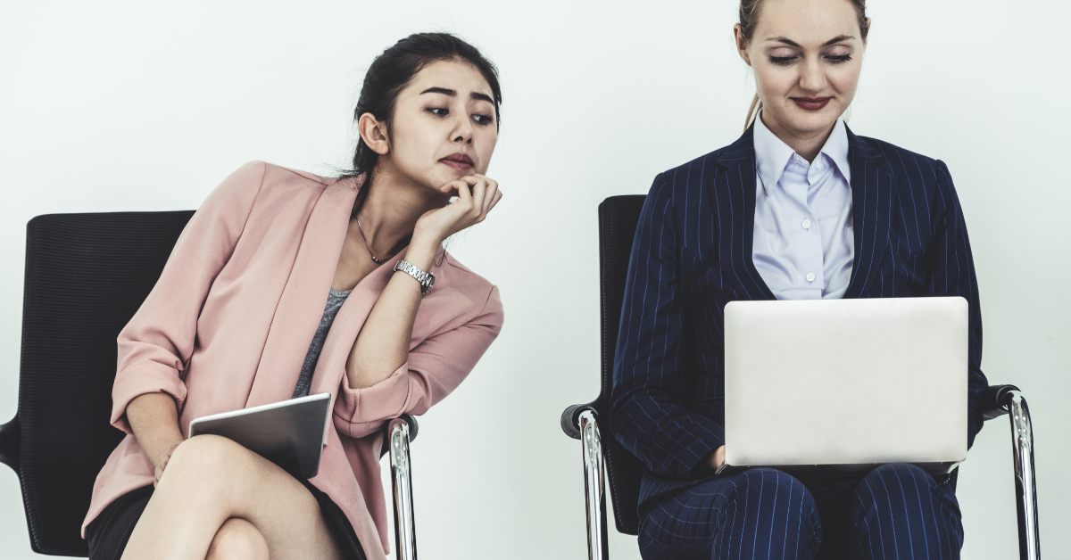 one woman looking over another woman's shoulder