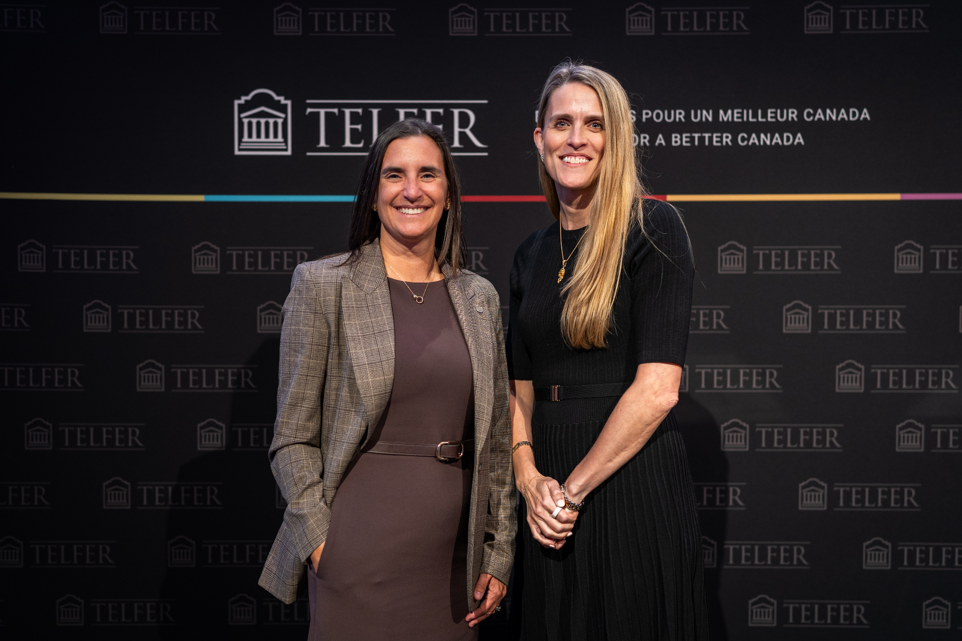 Bernadette Sarazin (left), wearing a patterned blazer over a brown dress, and Mélanie Hennessey (right), wearing a black dress