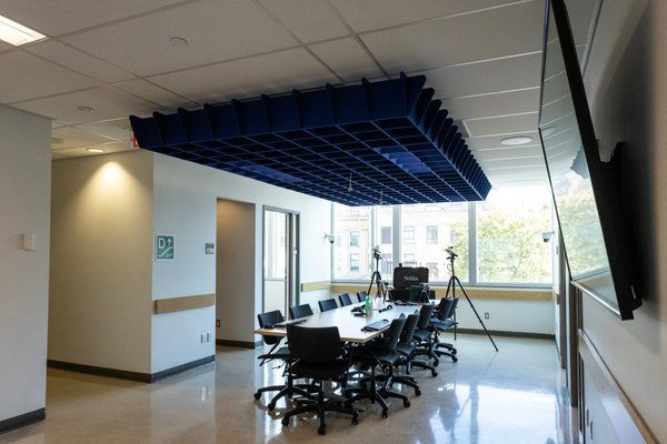 Une salle de conseil avec une table et douze chaises.