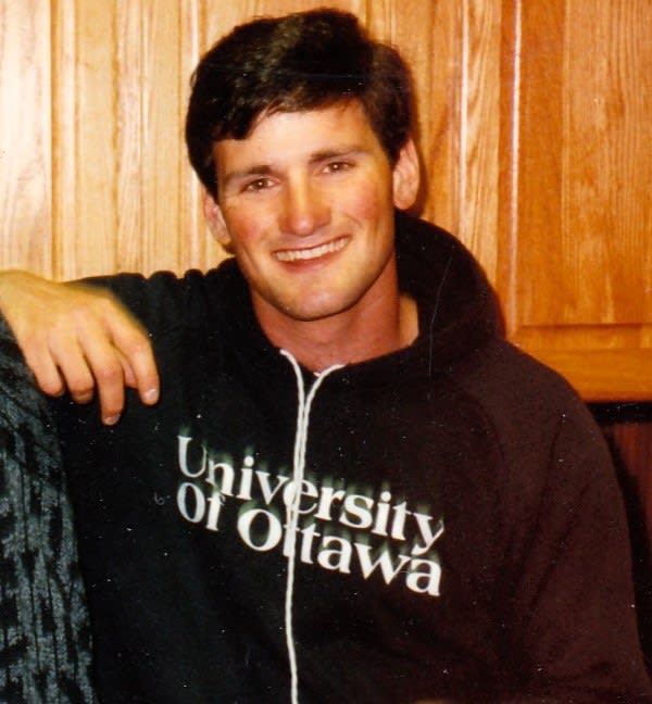 Headshot of young Myron Tetreault smiling at camera wearing a black University of Ottawa sweater.