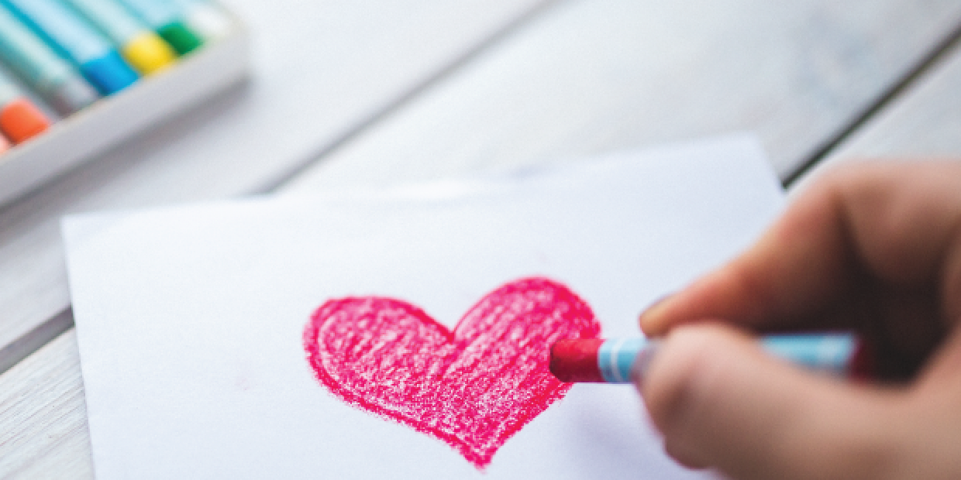 aa person drawing a heart on a piece of paper