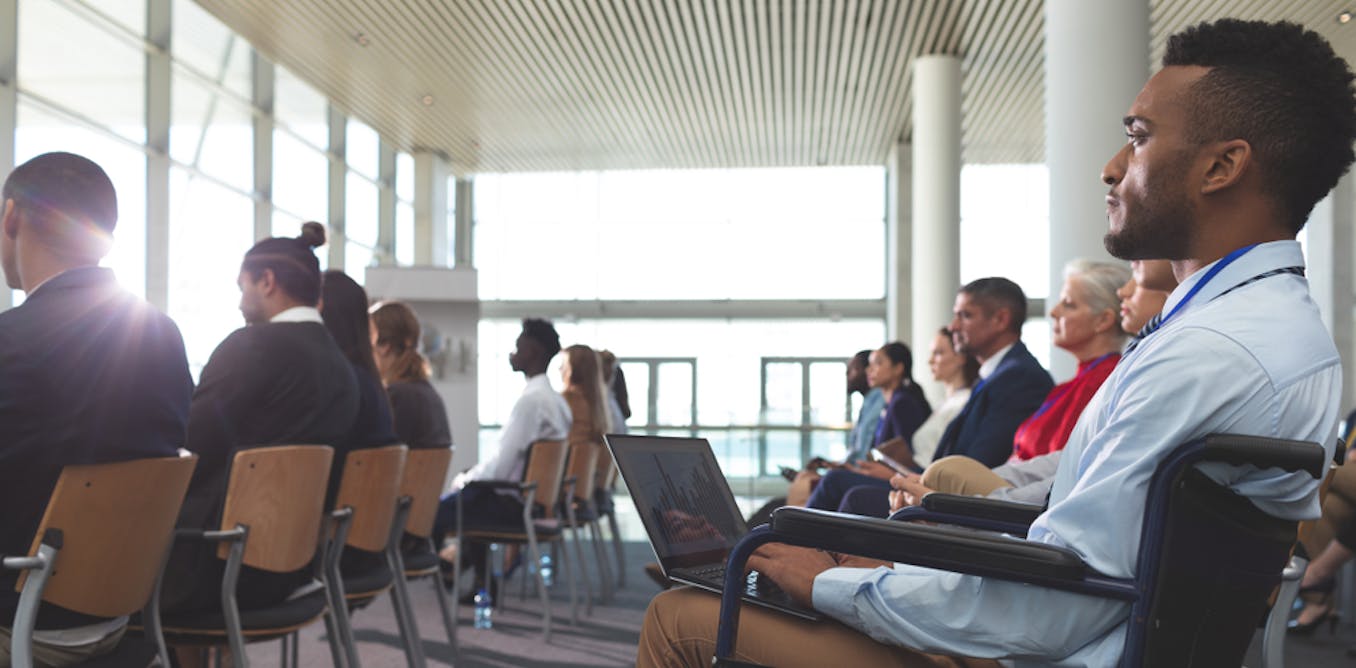 A group of people sitting in chairs looking out a window