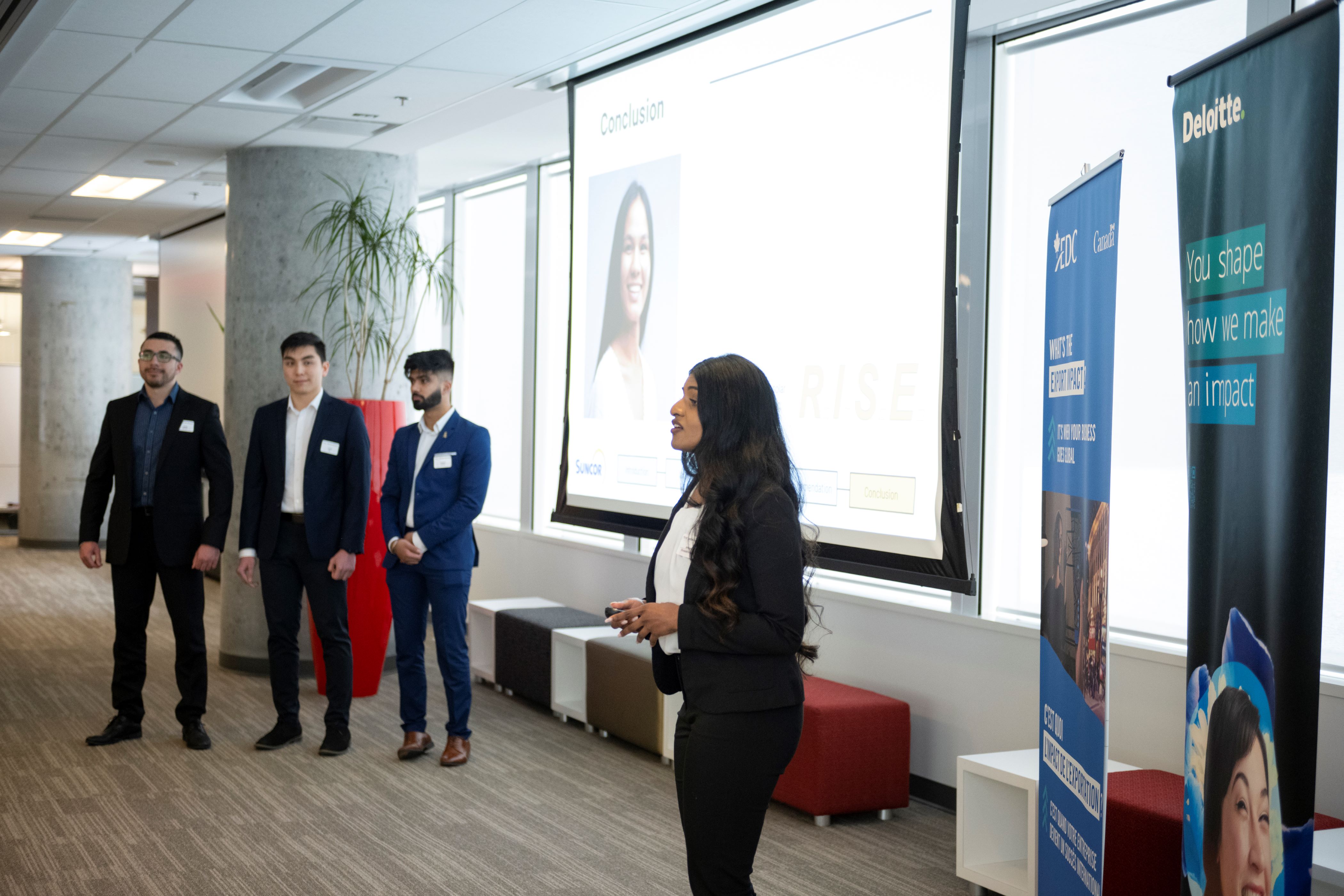 A team of MBA student presenting their solution to a panel of judges