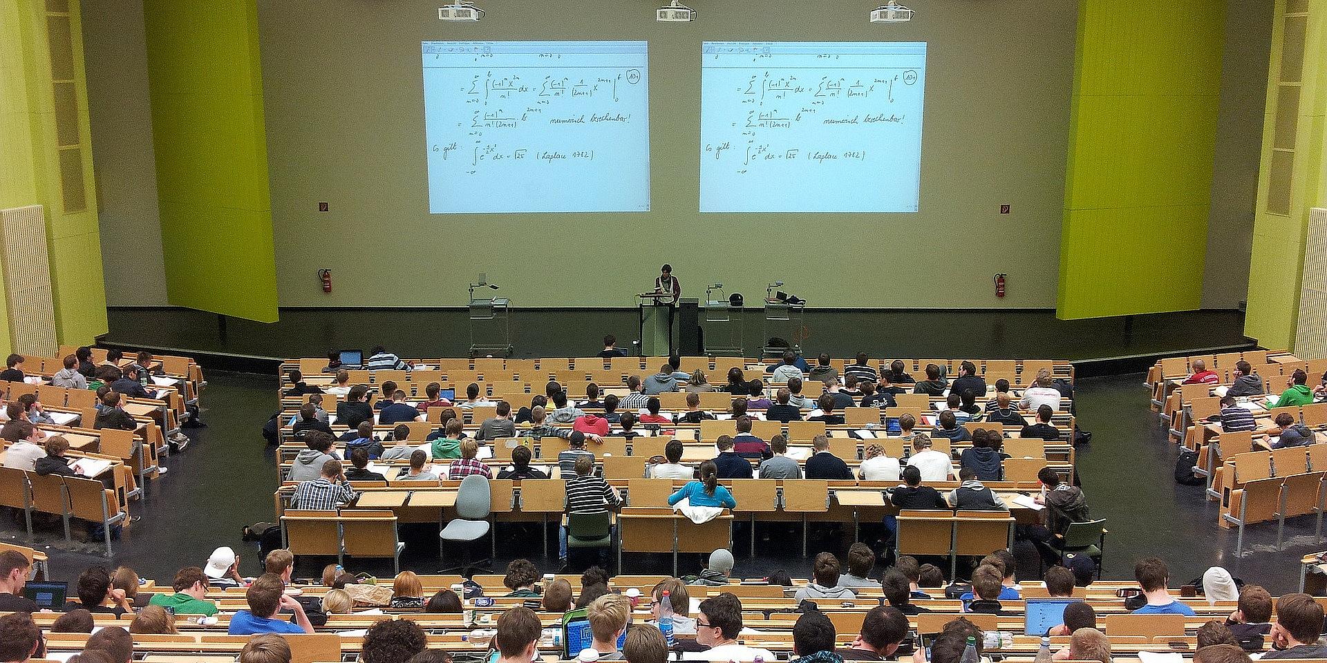 A university classroom with a math problem on the board