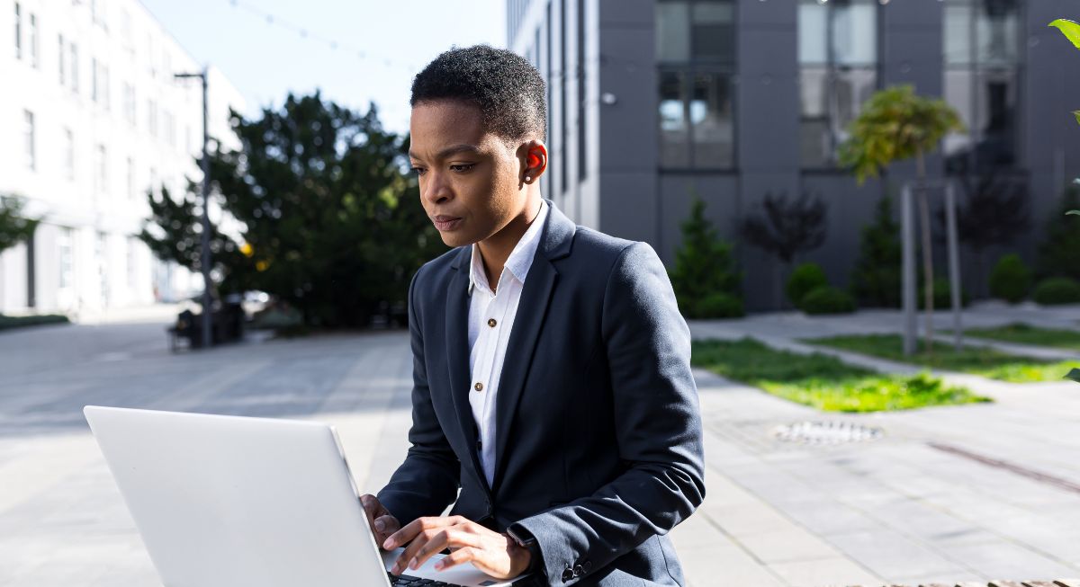BIPOC student using their laptop outside