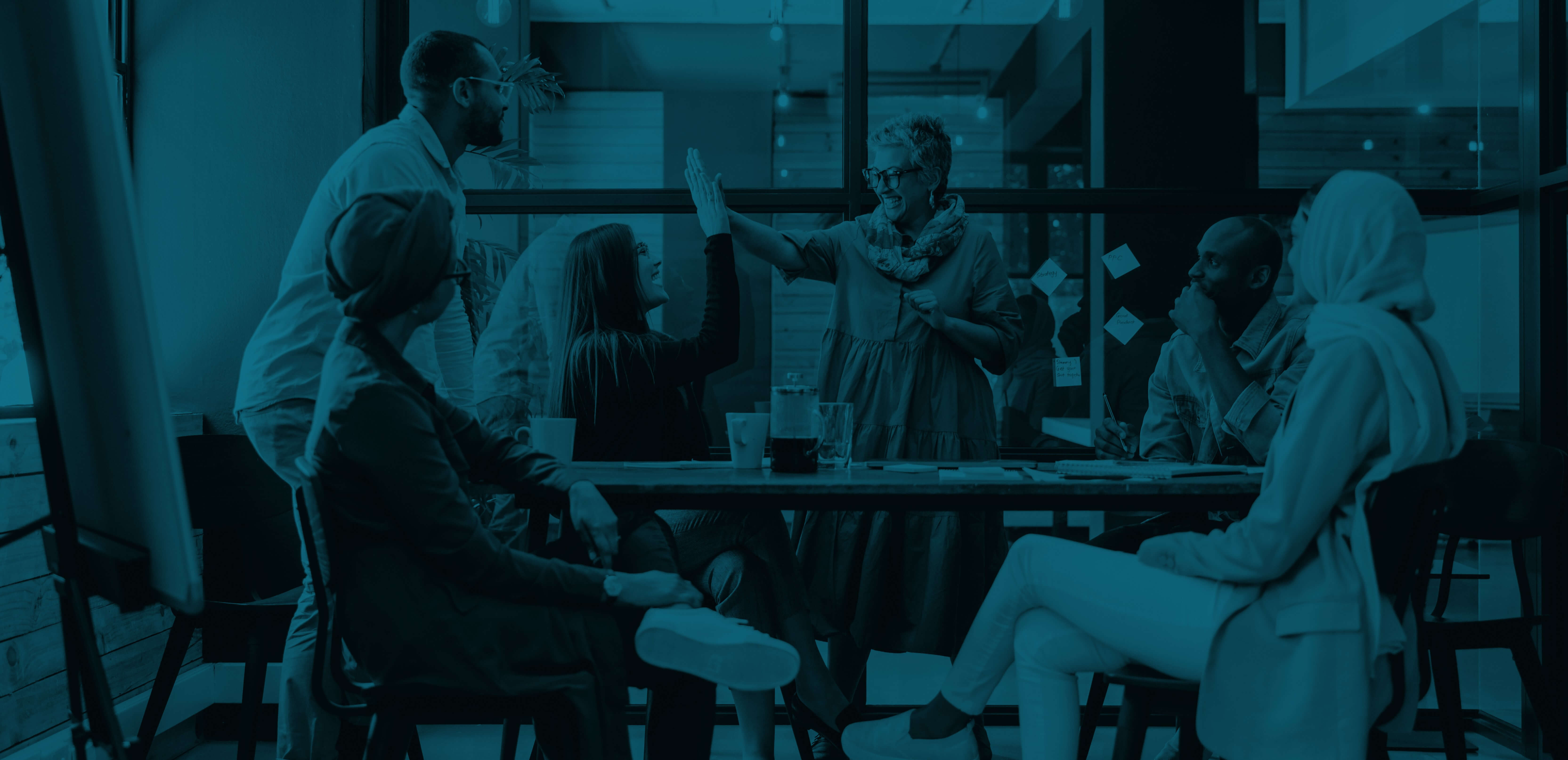 Blue tinted photo of six people around a table