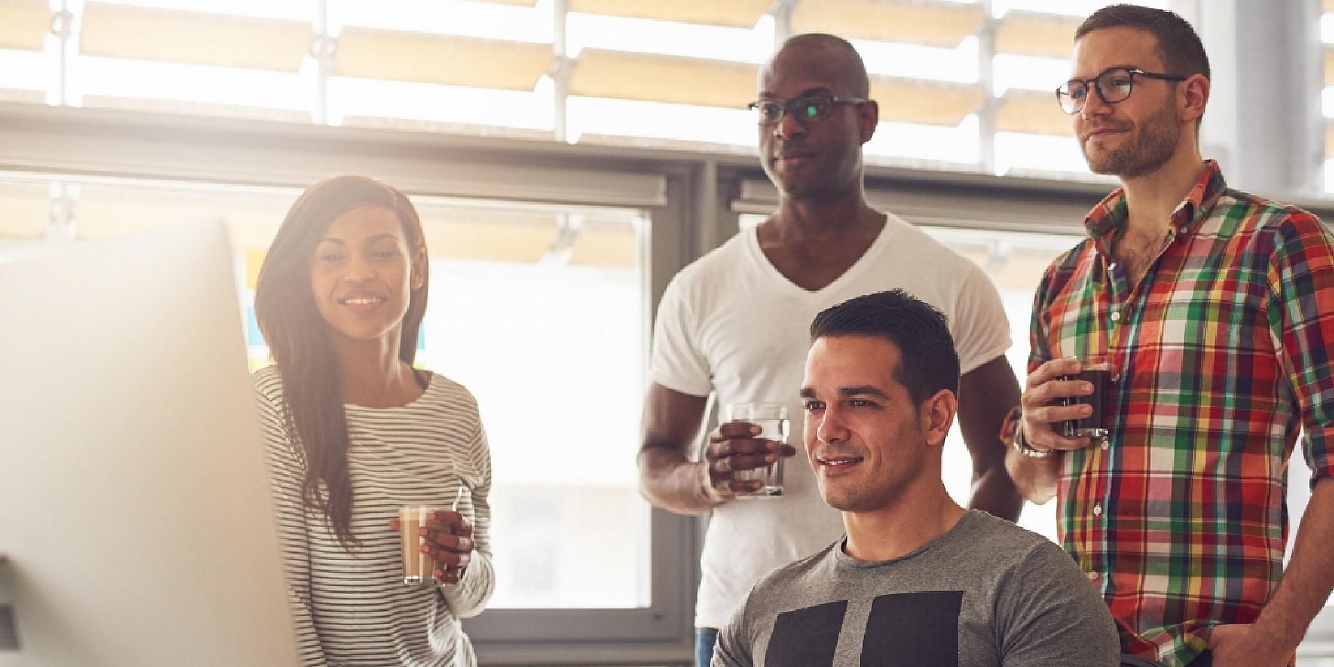 4 people looking at a whiteboard