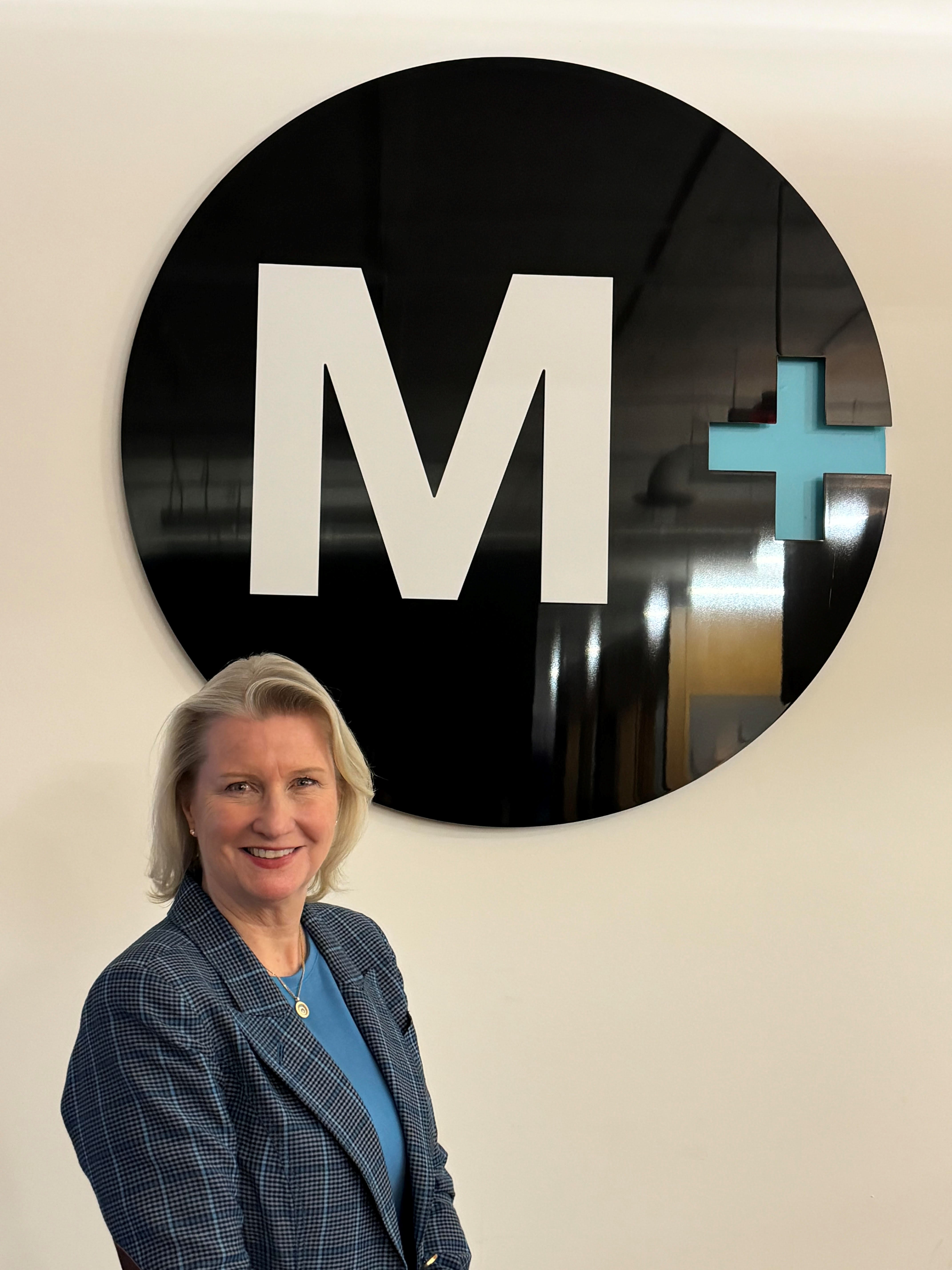 Christine Kincaid stands in front of a Mediaplus sign