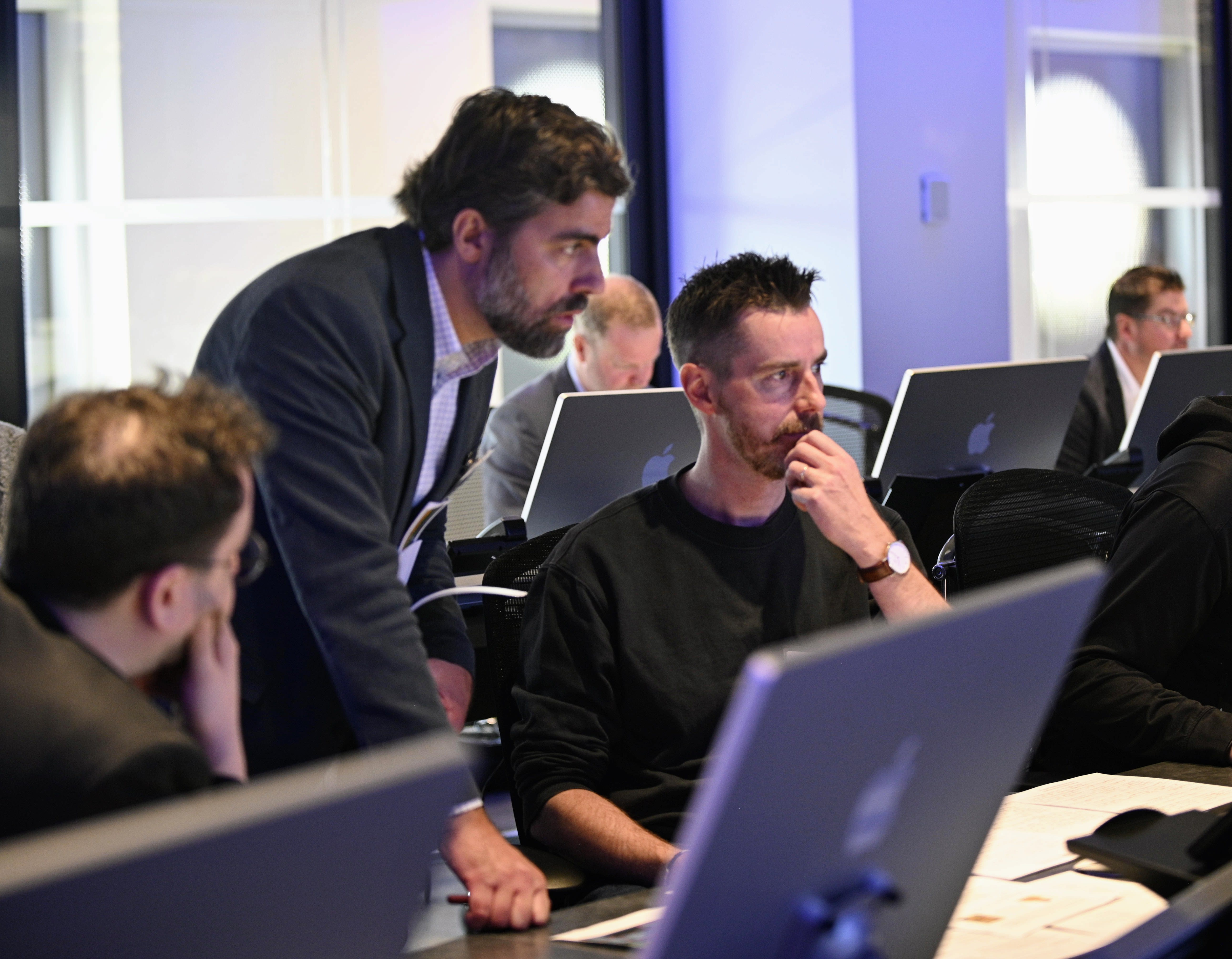 Three participants collaborate in front of a computer at the uOttawa-IBM Cyber Range.