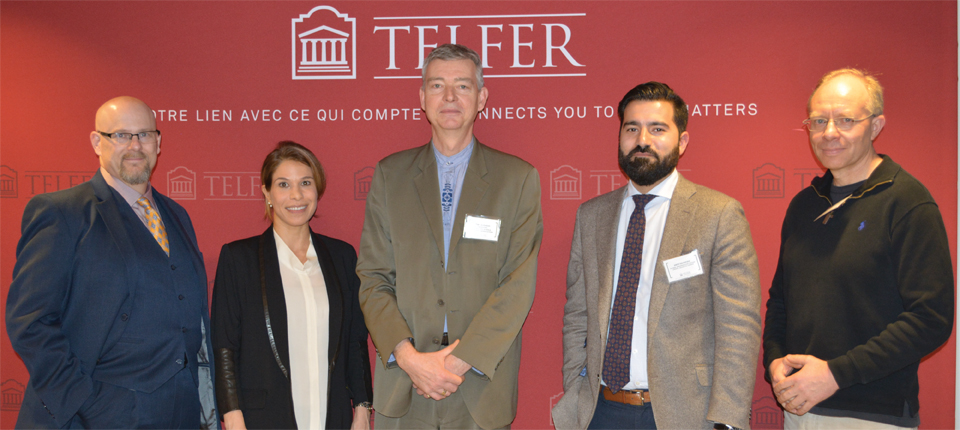 a group of experts standing in front of a telfer background
