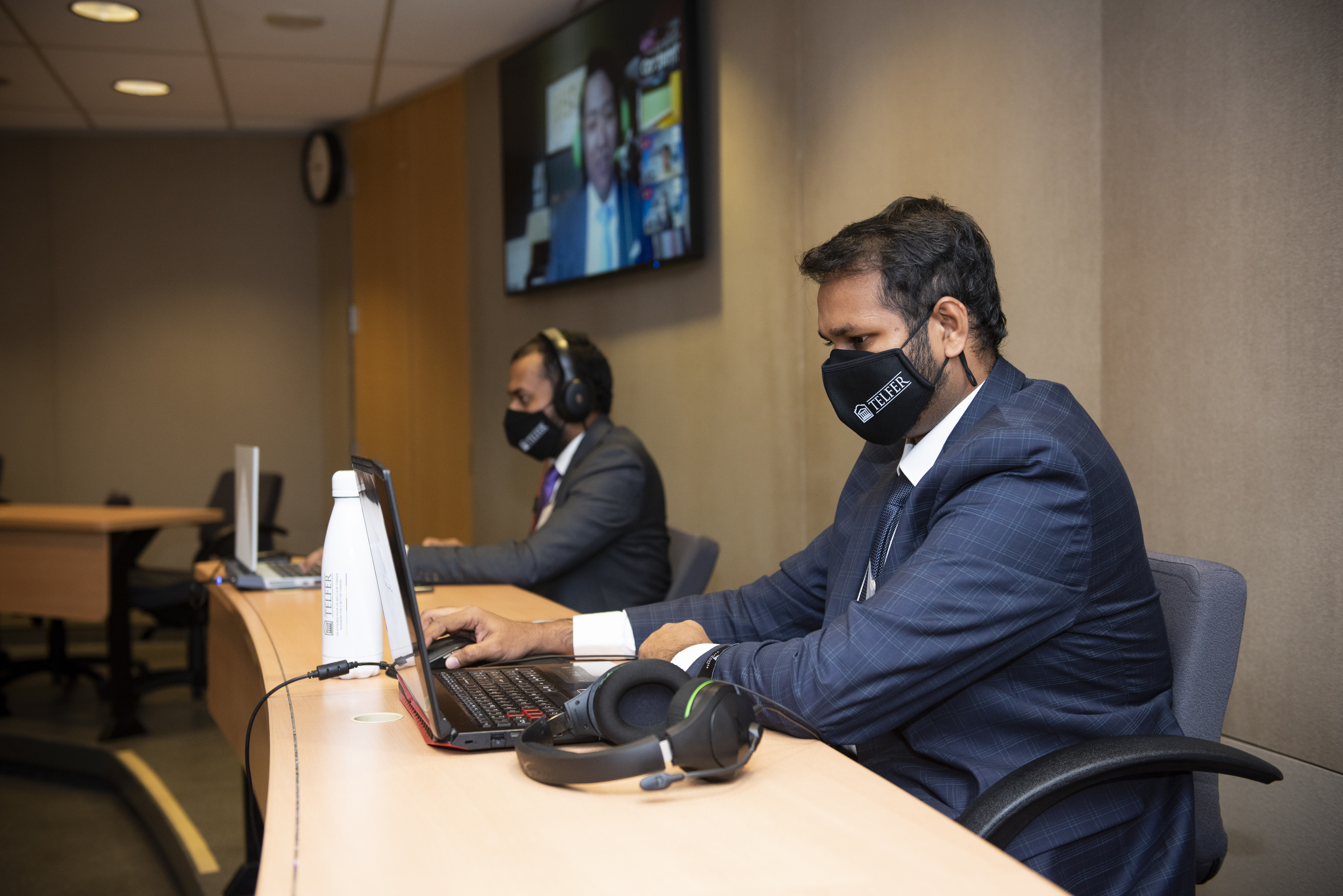 Deux étudiants travaillant devant leur ordi avec un masque