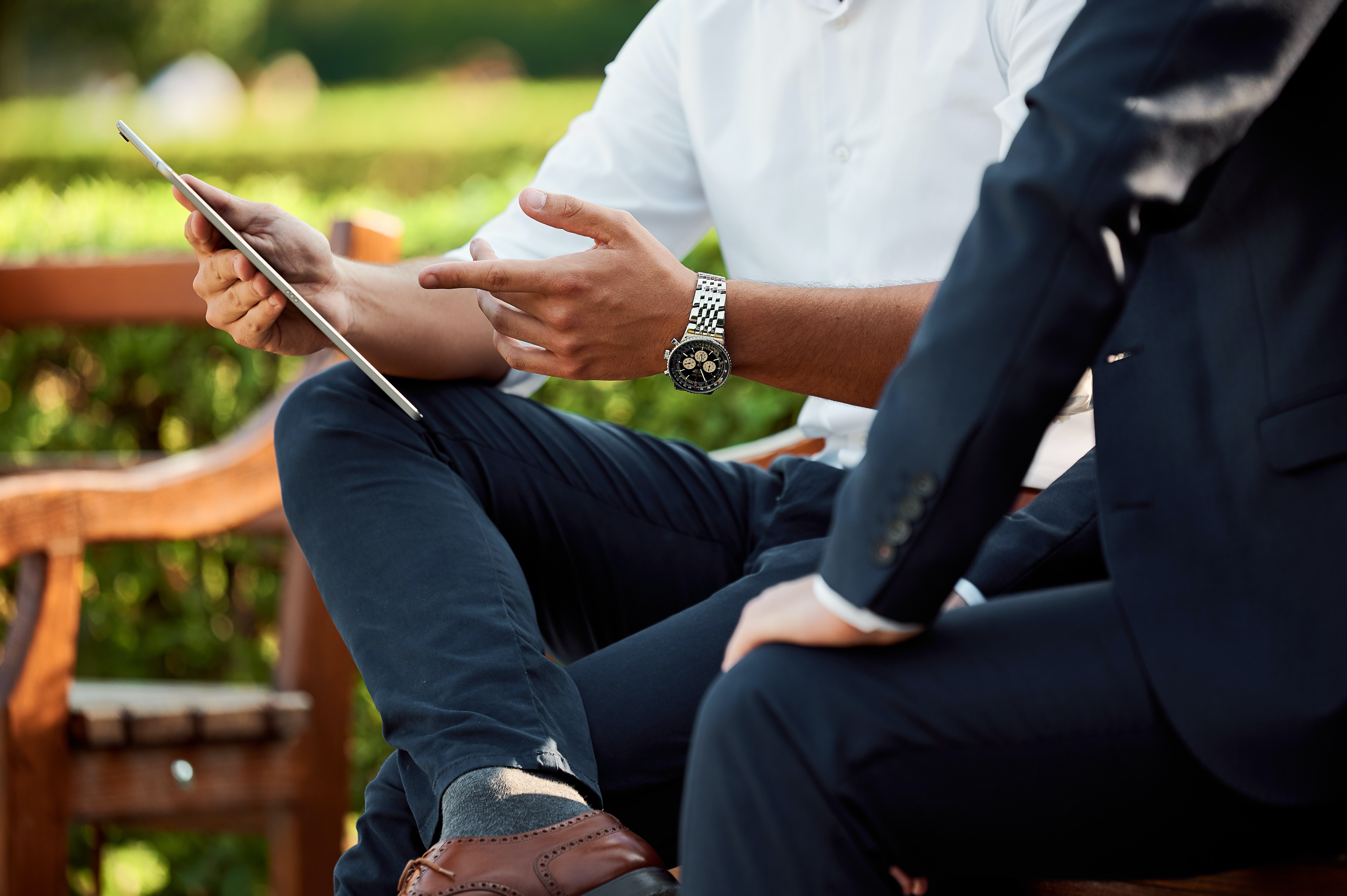 Two business people sitting together and pointing at a screen