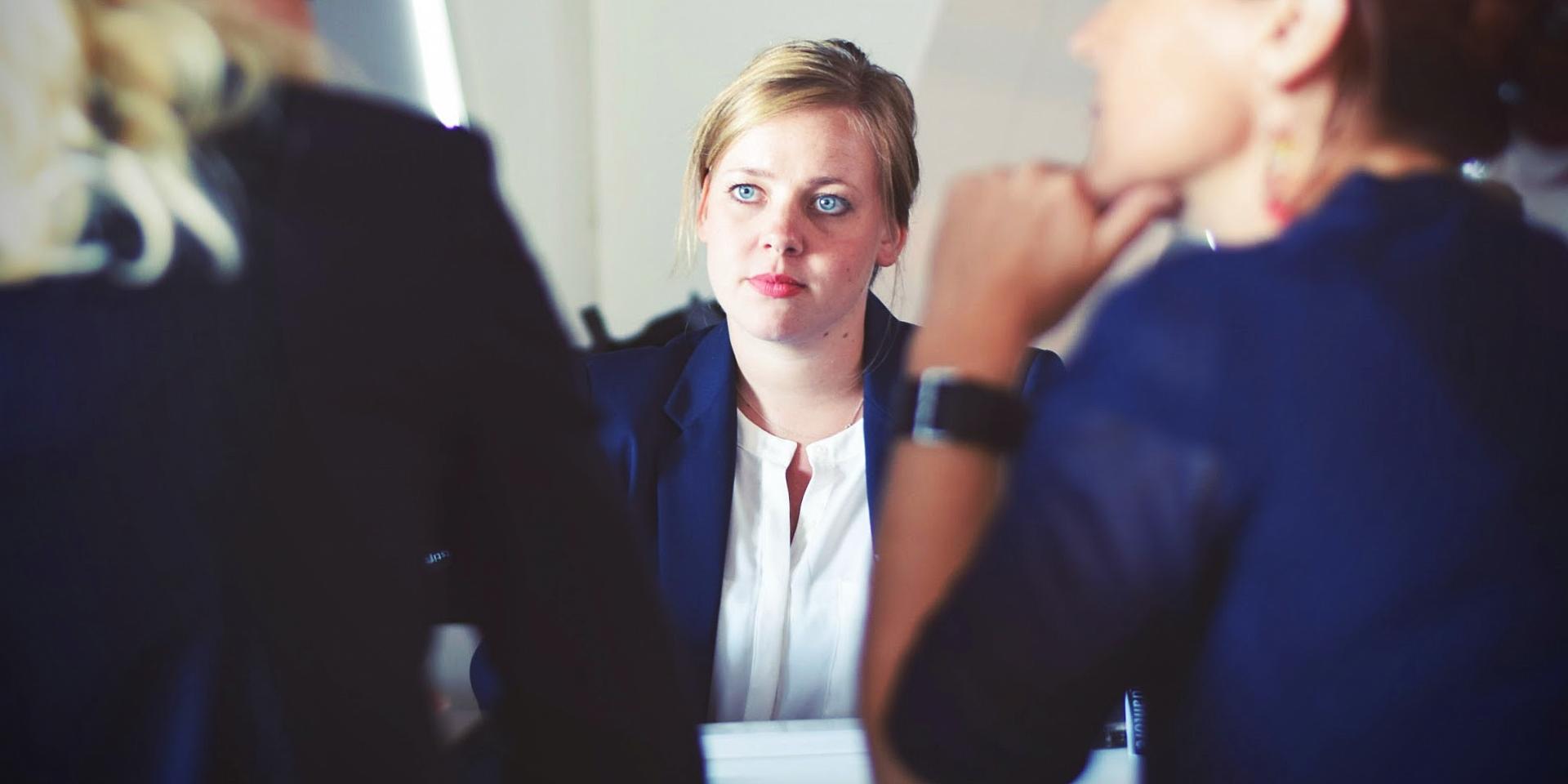 a person speaking to two other person across the table