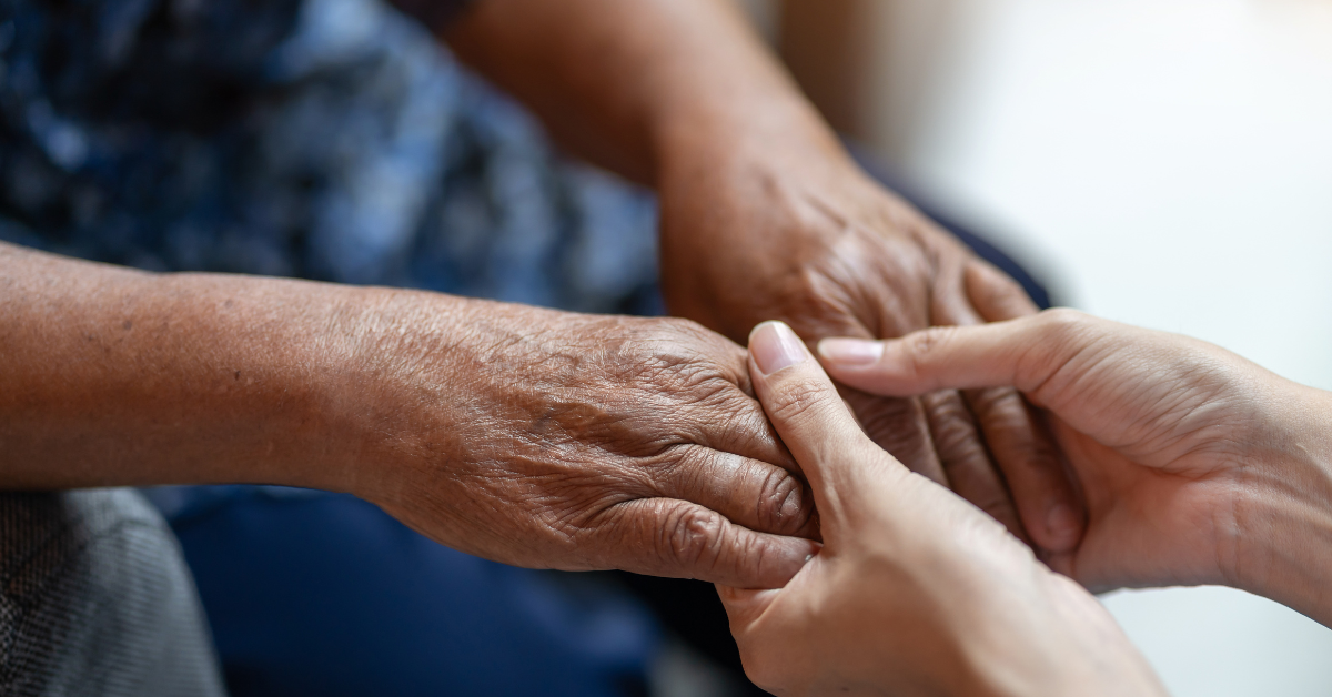 Elderly person holding the hands of another person