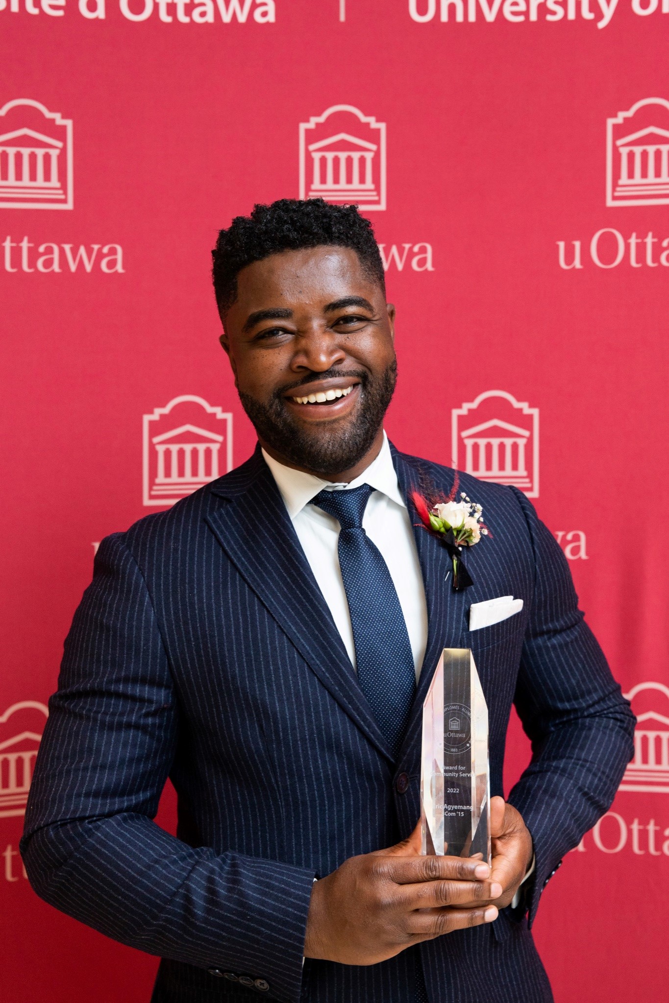 Eric Agyemang holding an award at the Alumni Excellence Award Gala