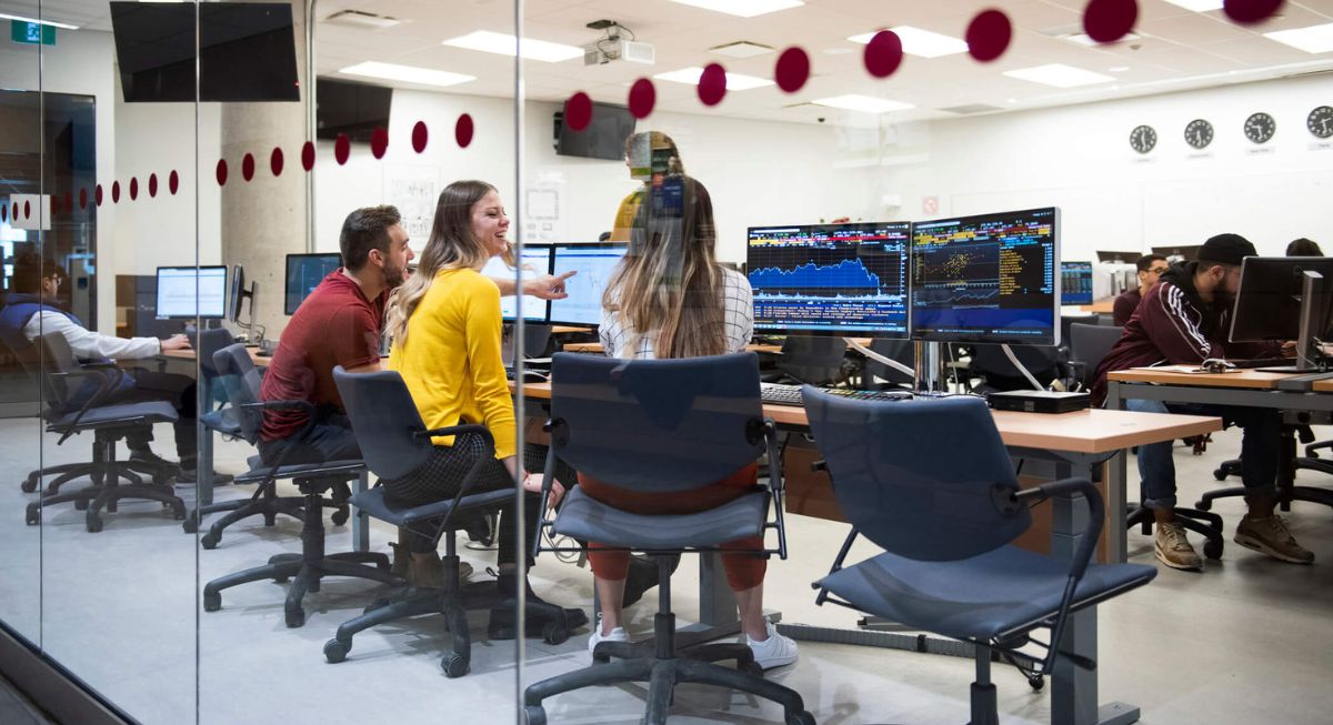 Group of Telfer students analyzing data together in the Financial Research and Learning Lab.