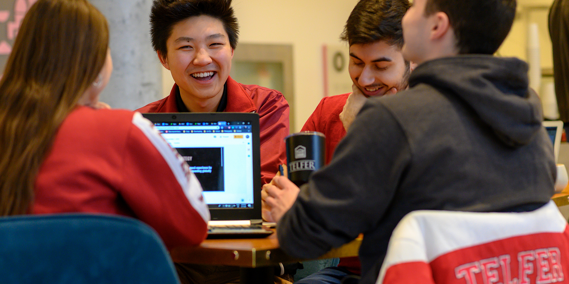 Groupe d'étudiants de Telfer qui sourient et étudient ensemble au pavillon Desmarais