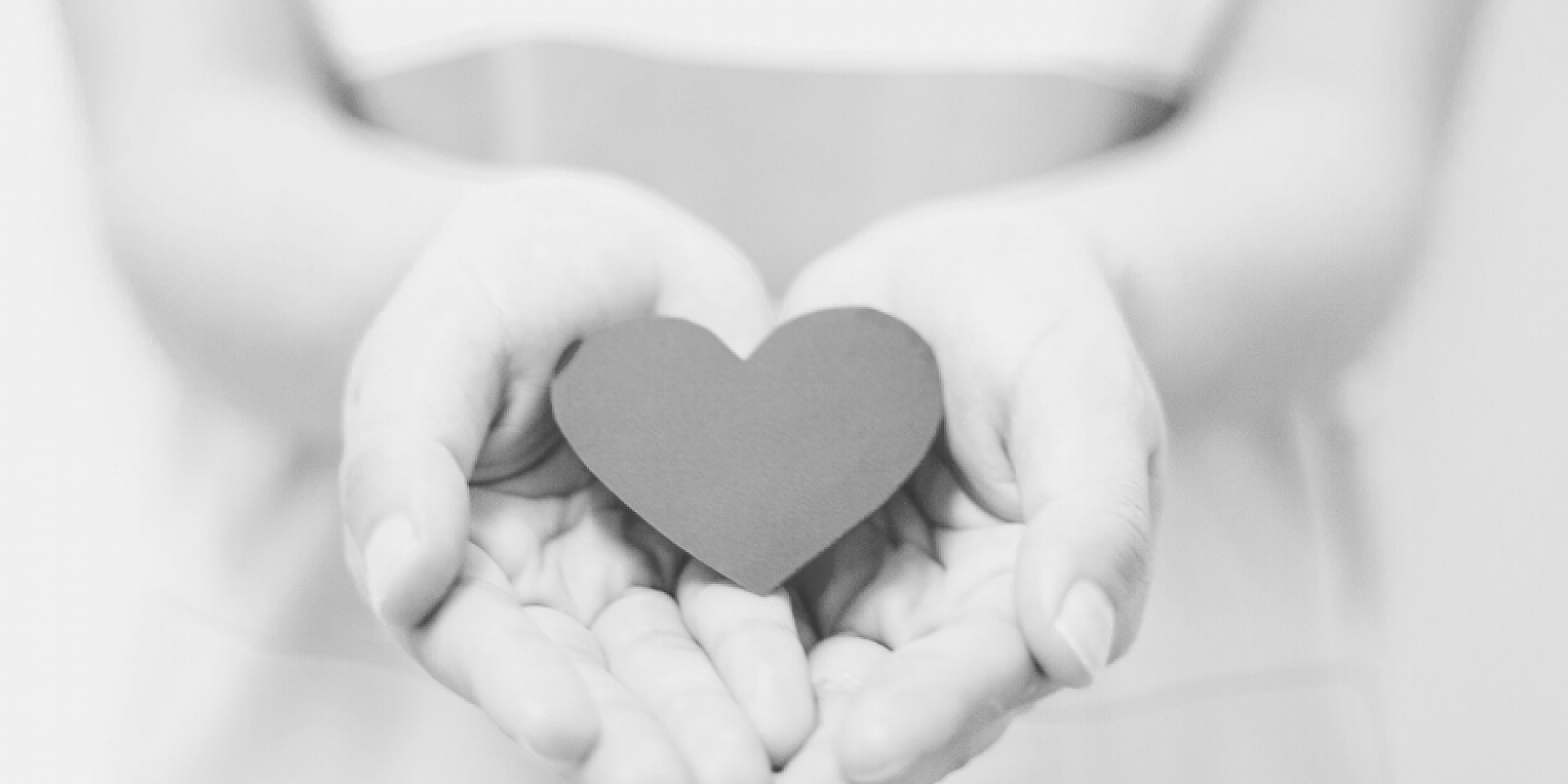 Hands holding a paper-shaped heart