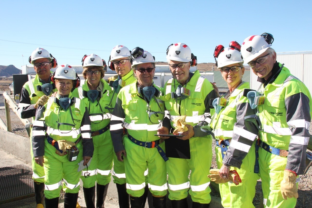 Ian Telfer et un groupe de personnes portant des casques de sécurité posent à GoldCorp