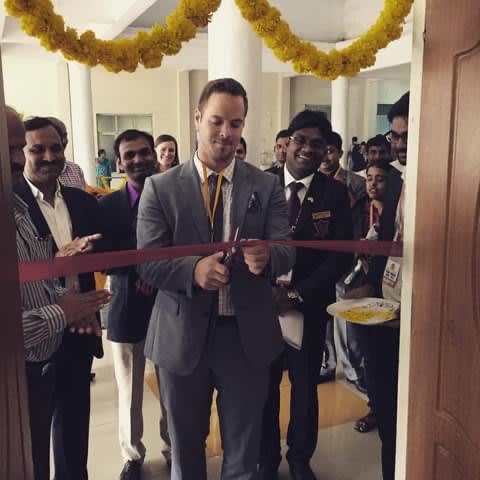 Micheal Weatherhead cutting a ceremonial ribbon at an event.
