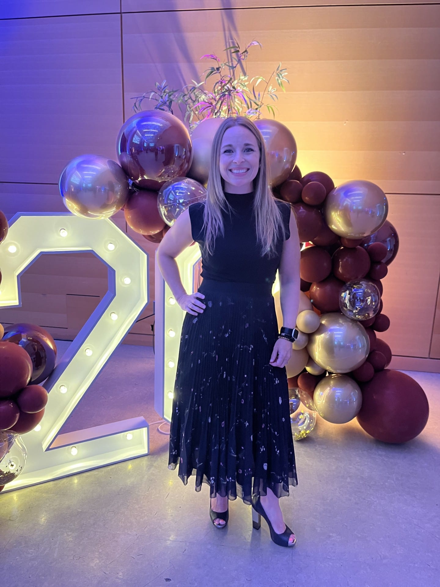 Amanda Richardson posing for a photo in front of a number twenty sign..