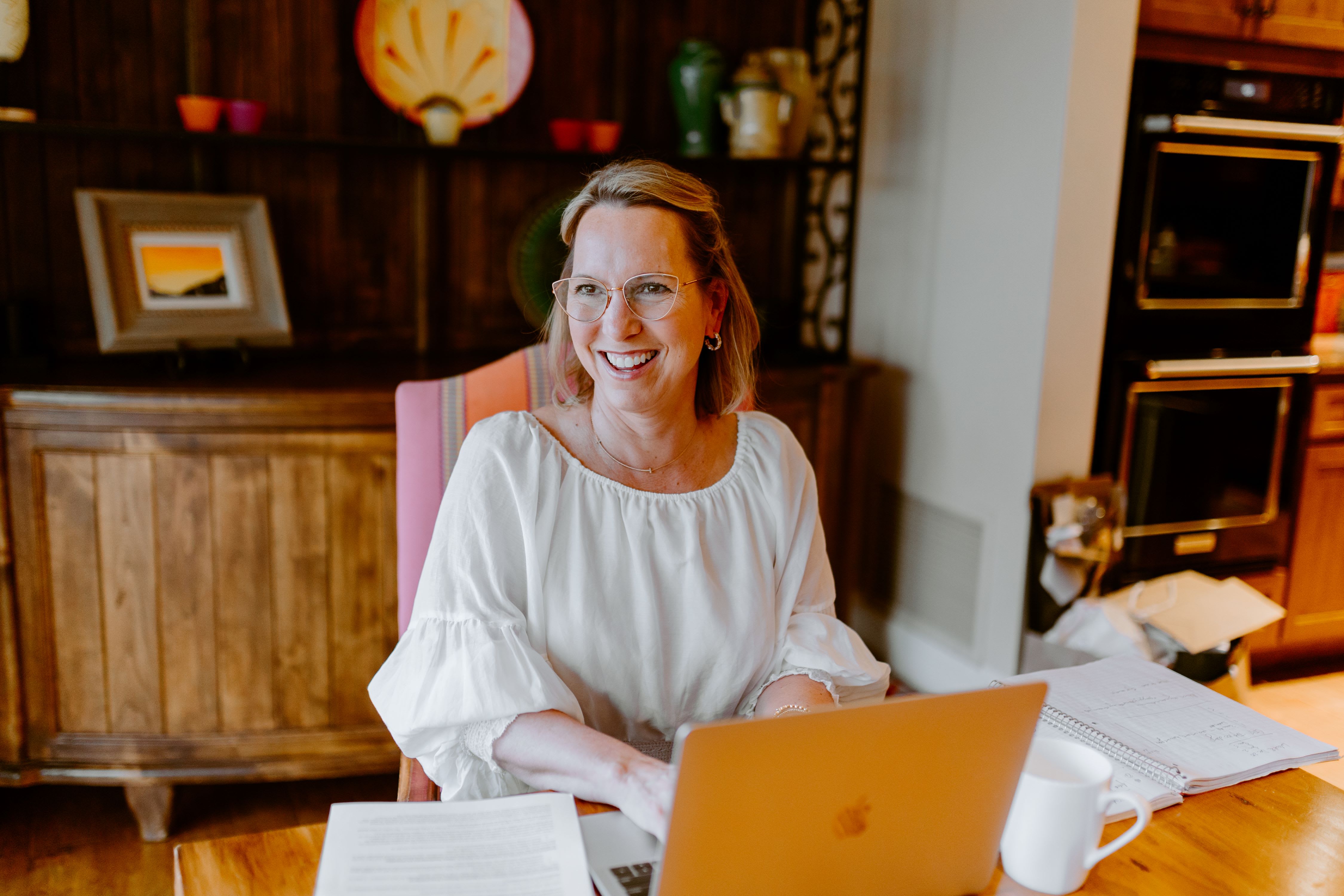 Kathryn Tremblay smiling while typing on a laptop in an office