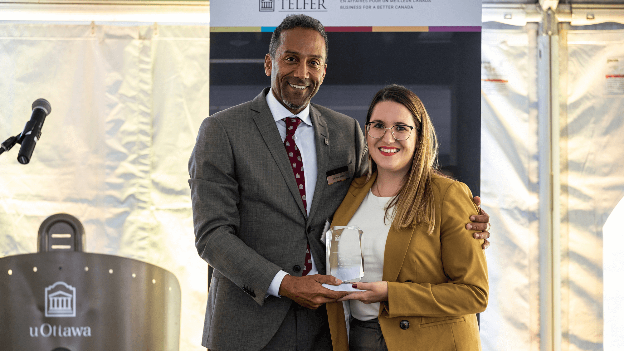 Kim Angéle Vallières poses for a photo smiling next to Dean Stéphane Brutus and holding her Young Donor of the Year Award