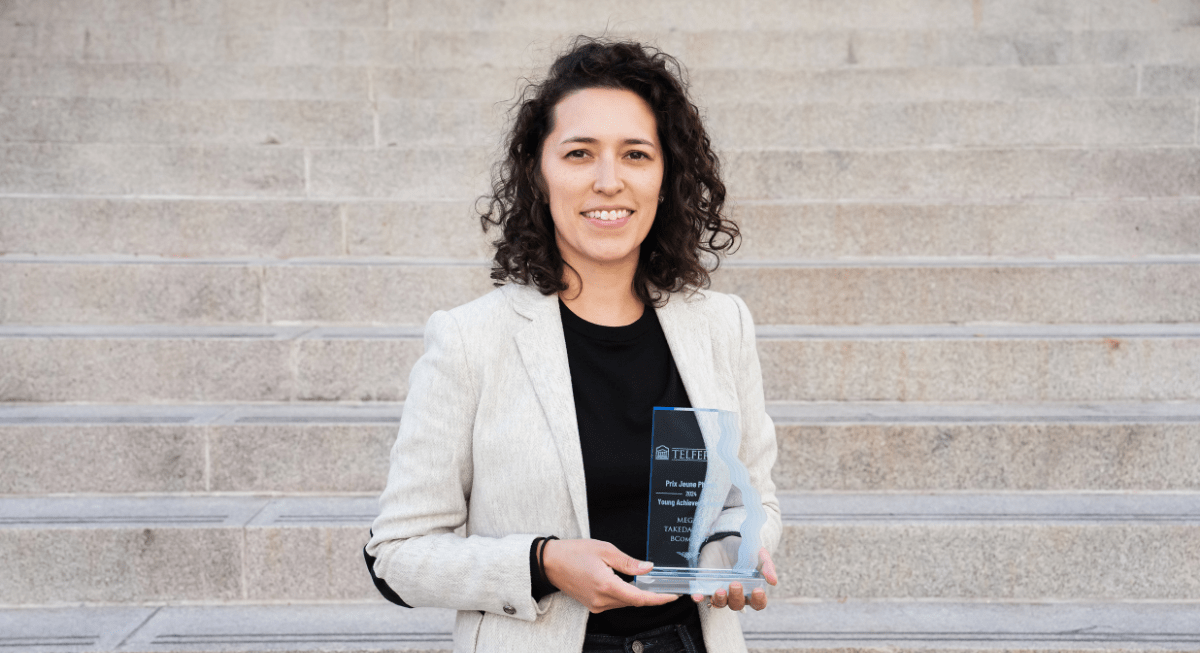 Megan Takeda-Tully holding a Telfer alumni award