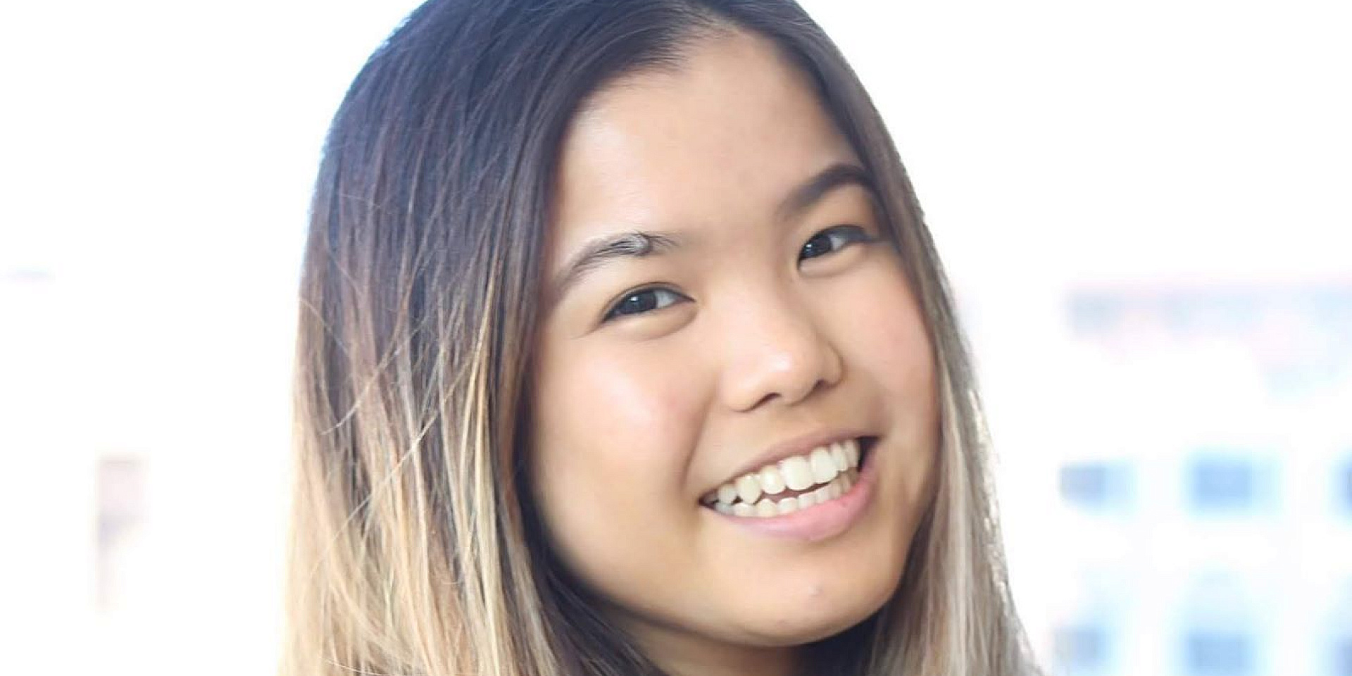 Melanie smiling in front of white background