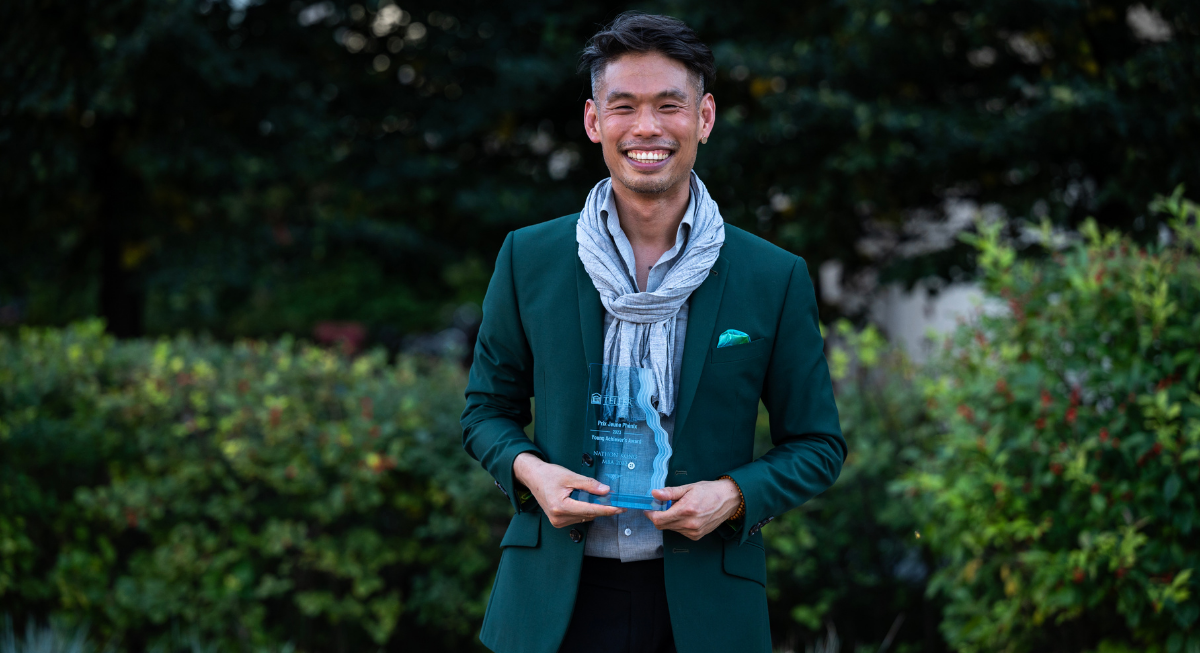Nathon Kong holding the Young Achiever Award